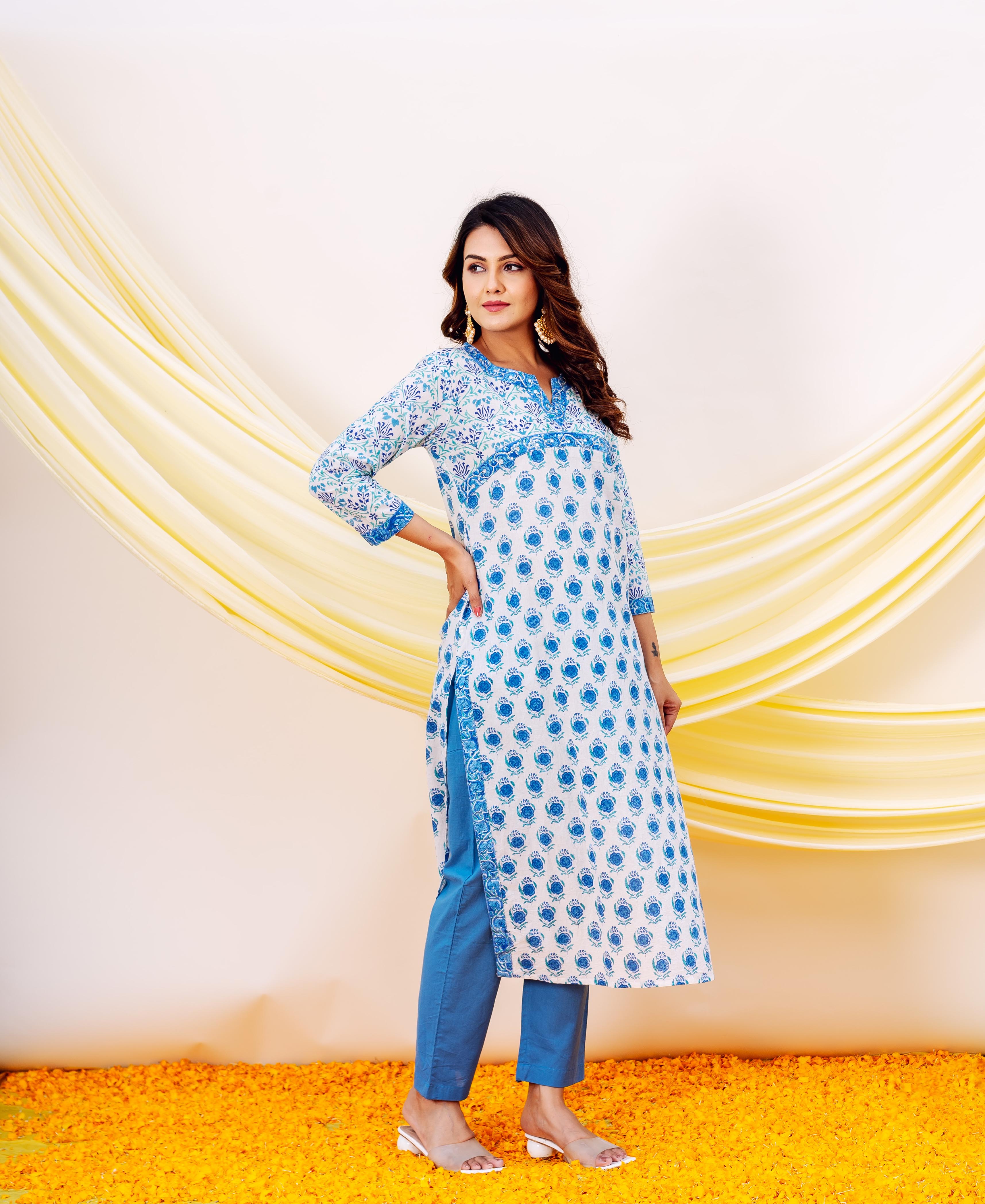 Woman modeling a white and blue floral hand-block printed cotton kurta and matching blue pants.