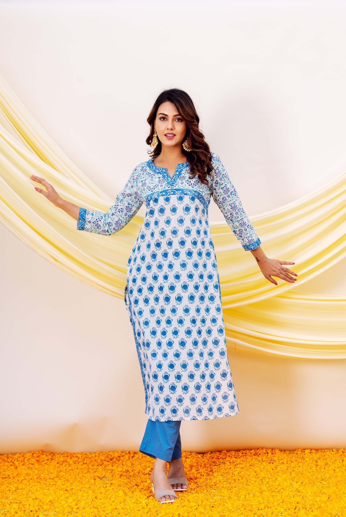 Woman wearing white and blue hand-block-printed cotton kurta with blue accents and patterned cuffs.