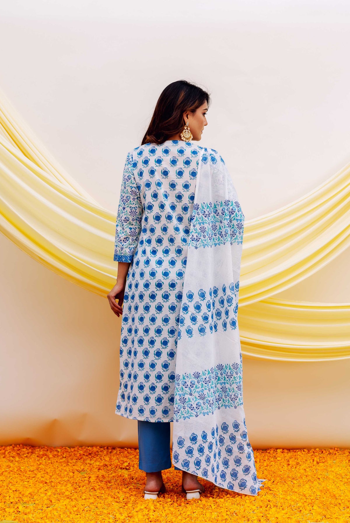 A woman wearing a white and blue hand-block-printed kurta with a floral pattern.
