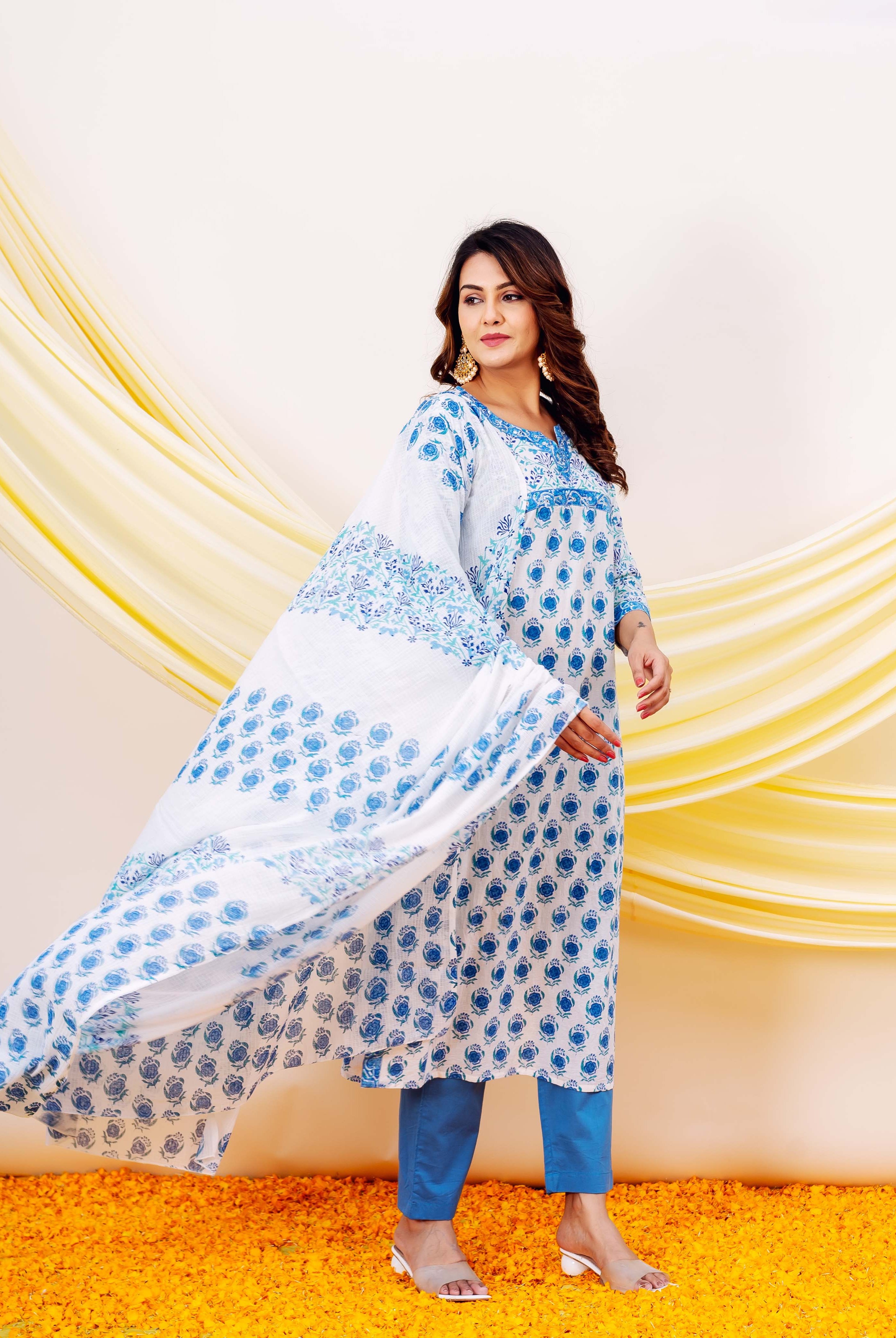 A woman in a white and blue hand-block-printed kurta with a matching dupatta.
