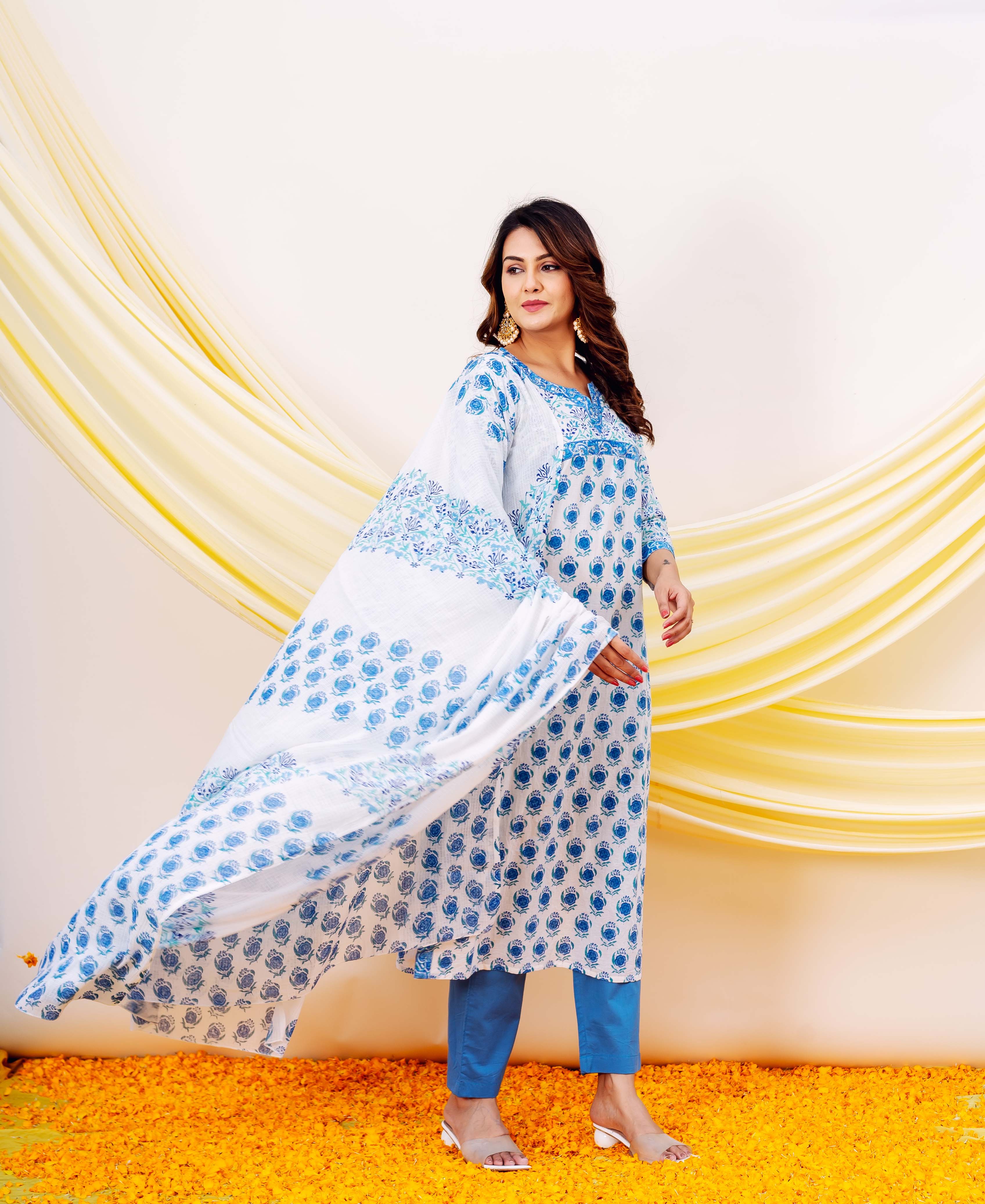 A woman in a white and blue hand-block-printed kurta with a matching dupatta.