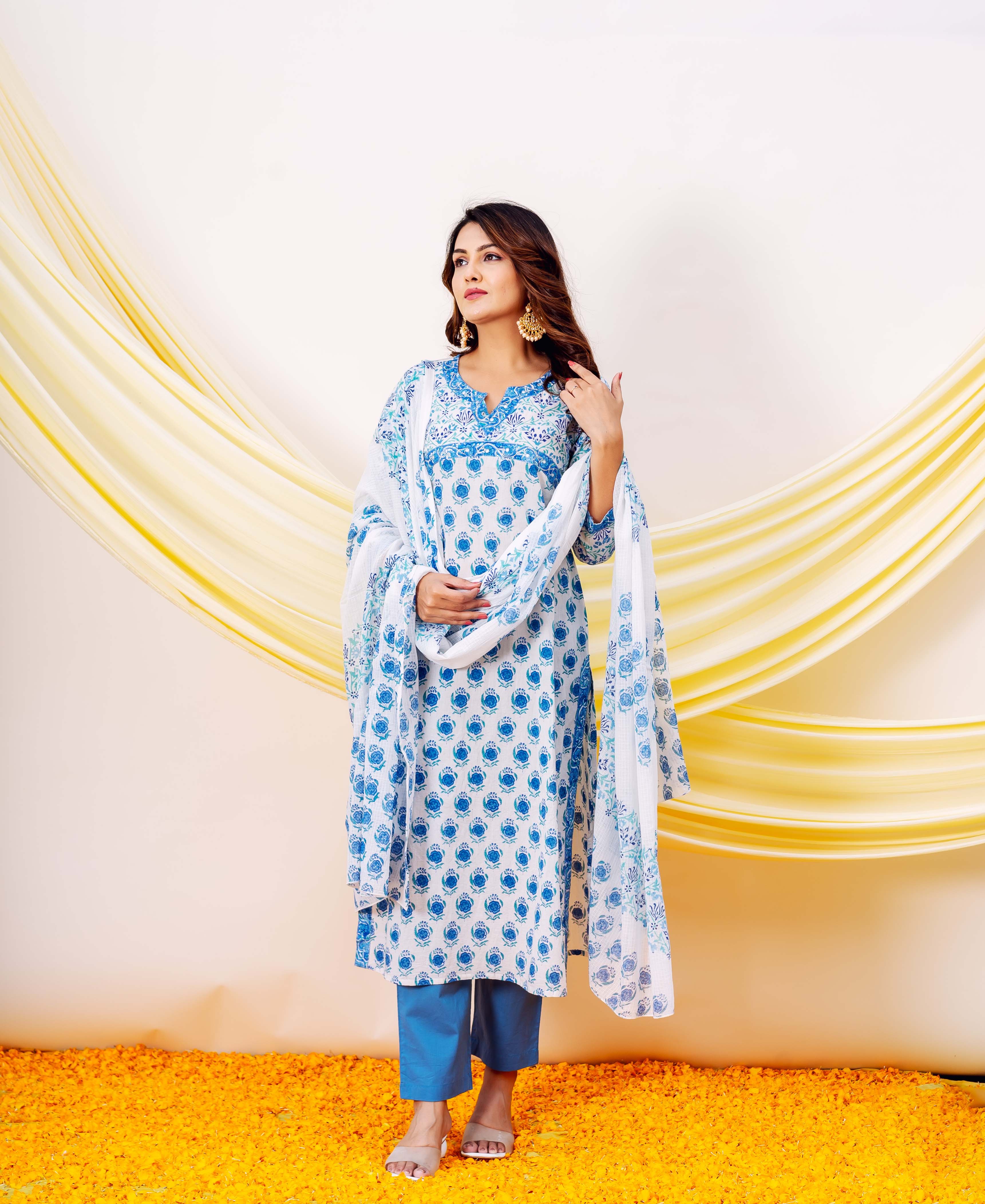 Woman wearing white and blue hand-block-printed cotton kurta with floral patterns and blue pants.