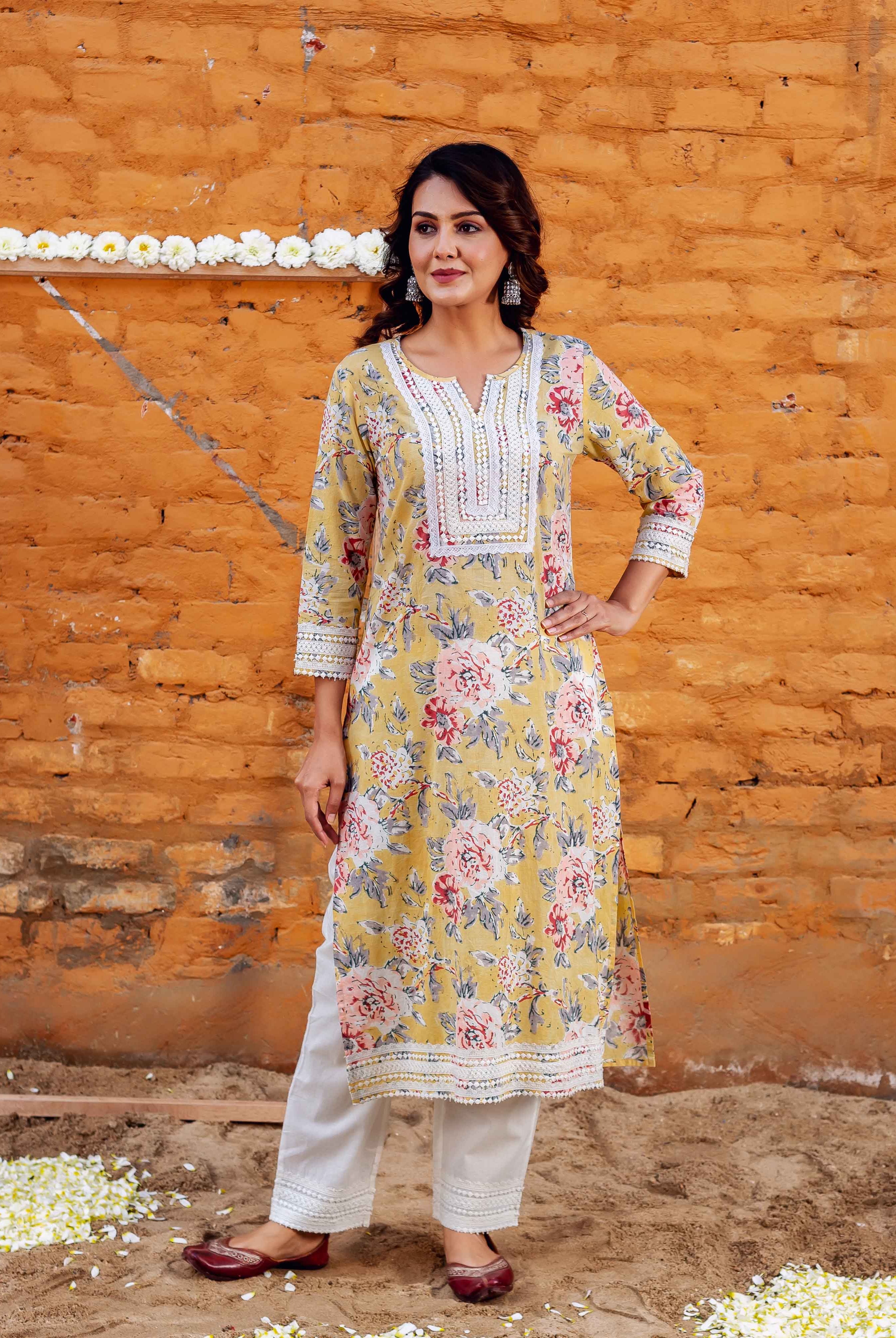 Woman in yellow kurta with pink & white floral block print, white lace, and white pants.