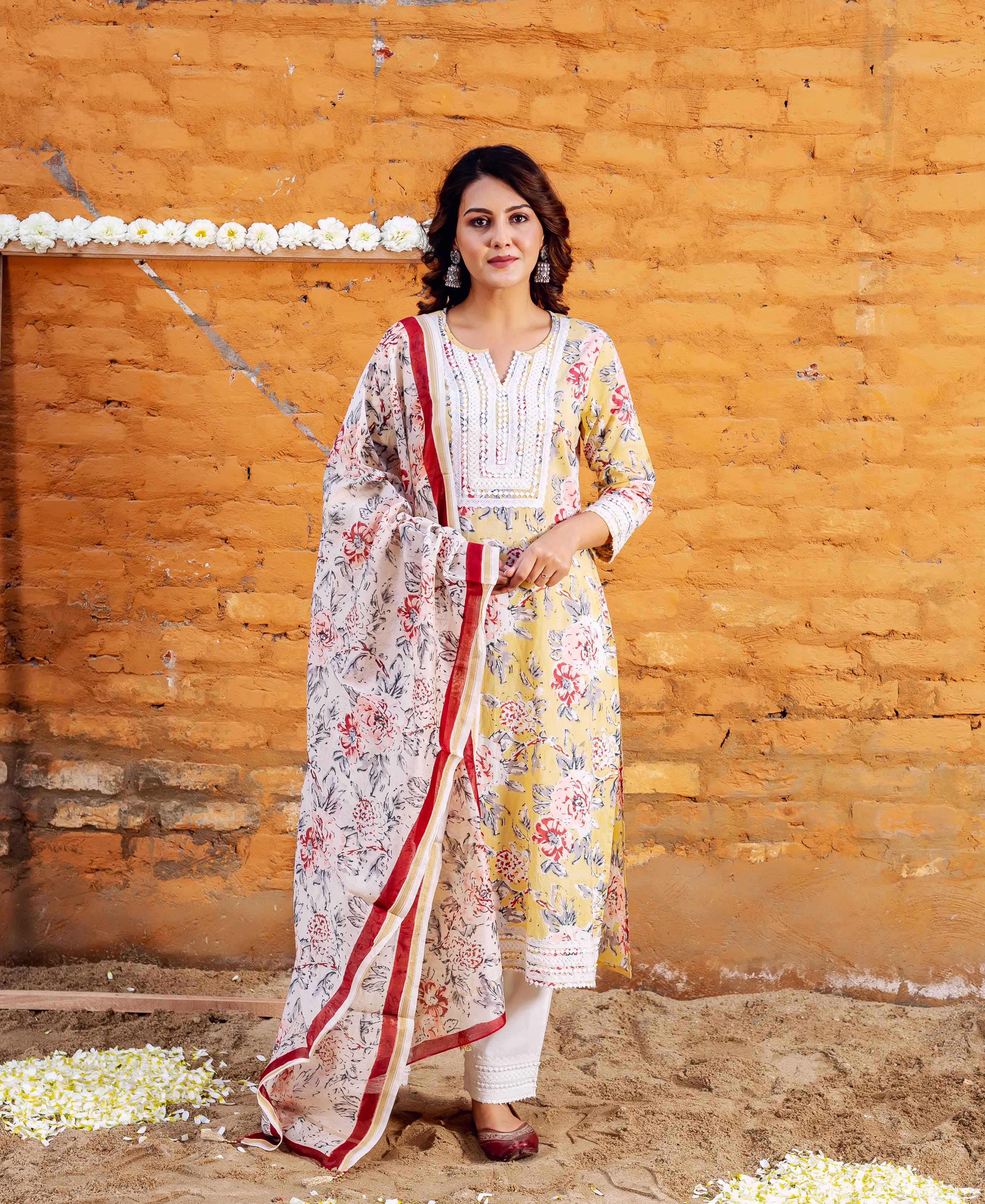 Full-length front view of a model wearing a yellow floral block printed kurta set with white lace.