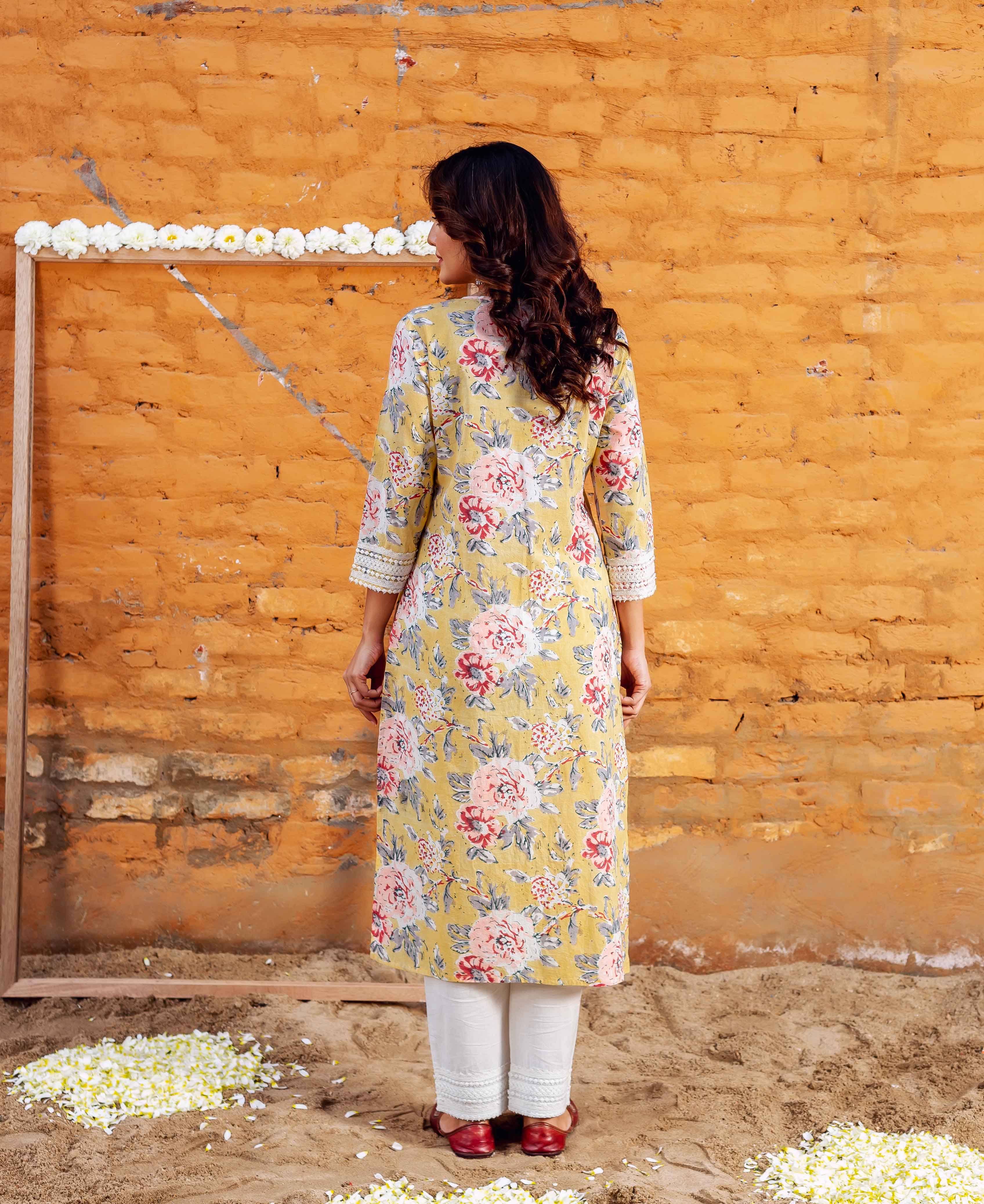 Back view of model in a sunflower yellow block printed floral kurta with white lace.