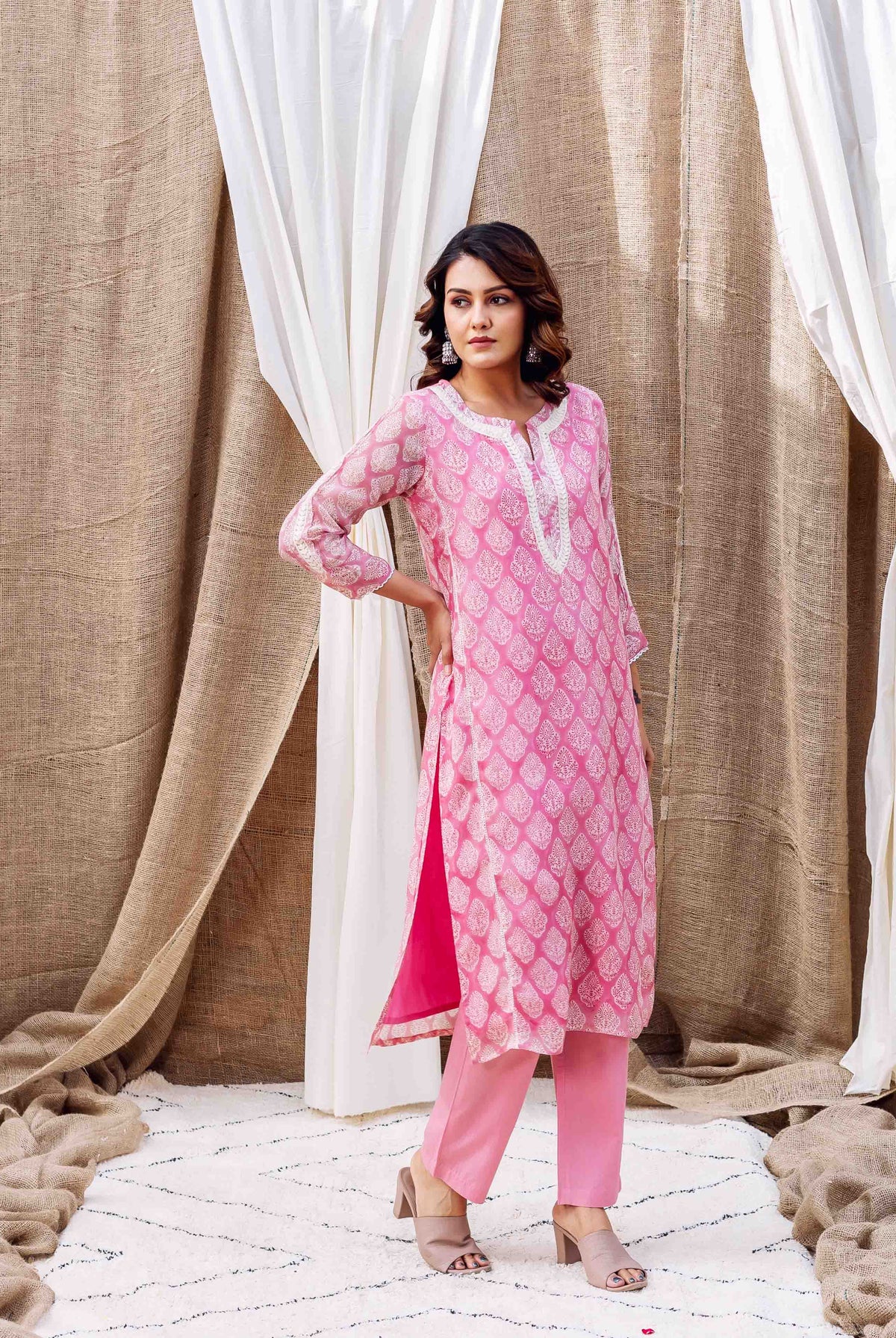 Model in a full shot blush pink organza kurta set with white abstract leaf print.