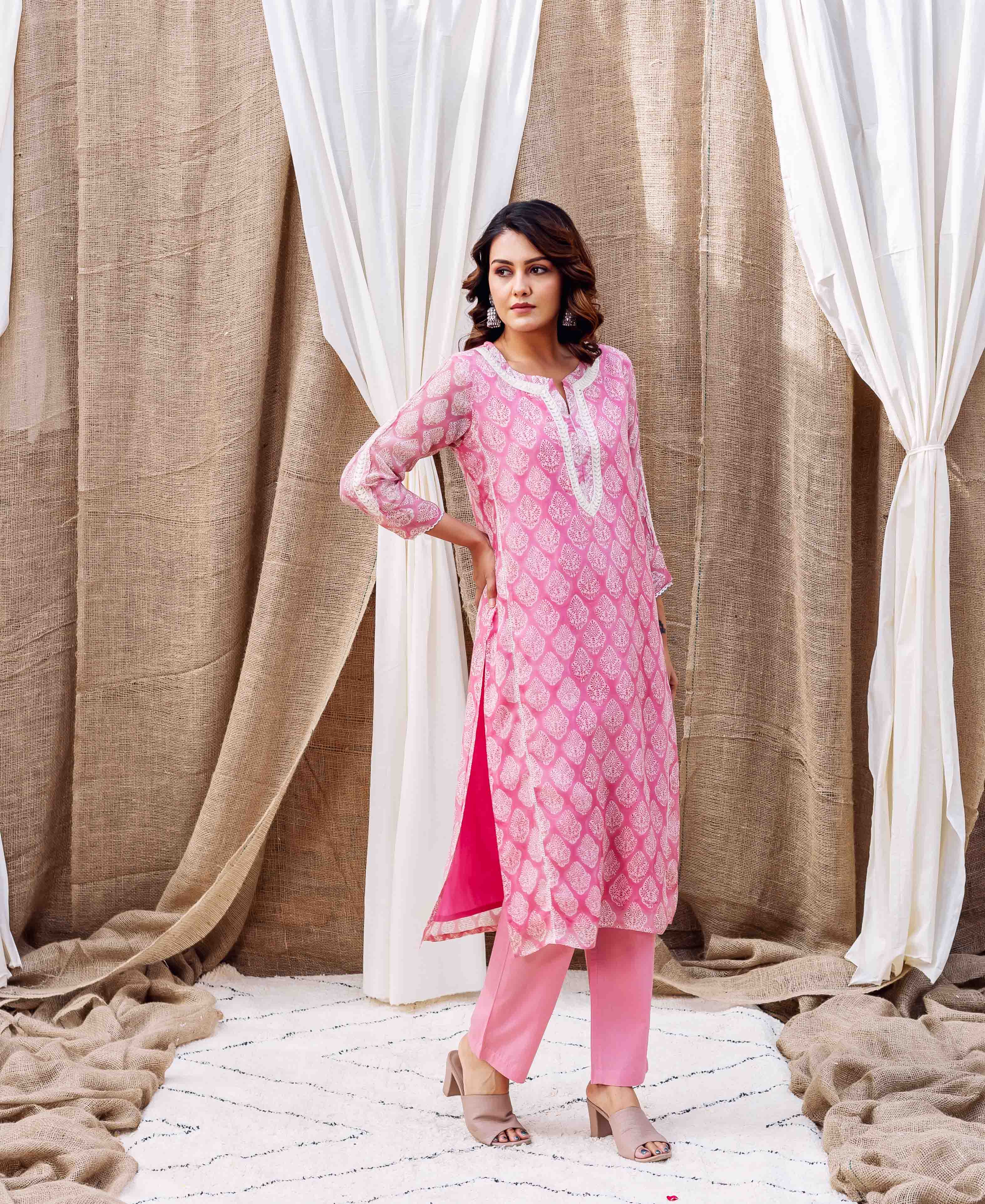 Model in a full shot blush pink organza kurta set with white abstract leaf print.