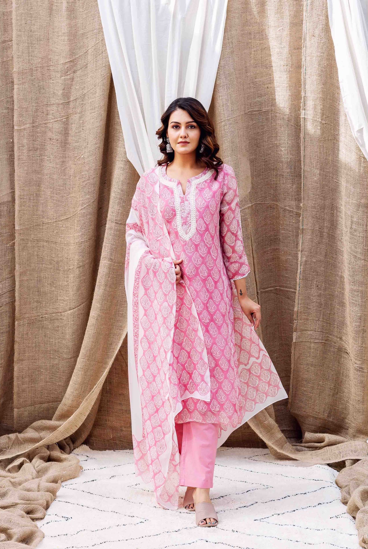 Model wearing blush pink hand-block printed organza kurta set with white pattern.