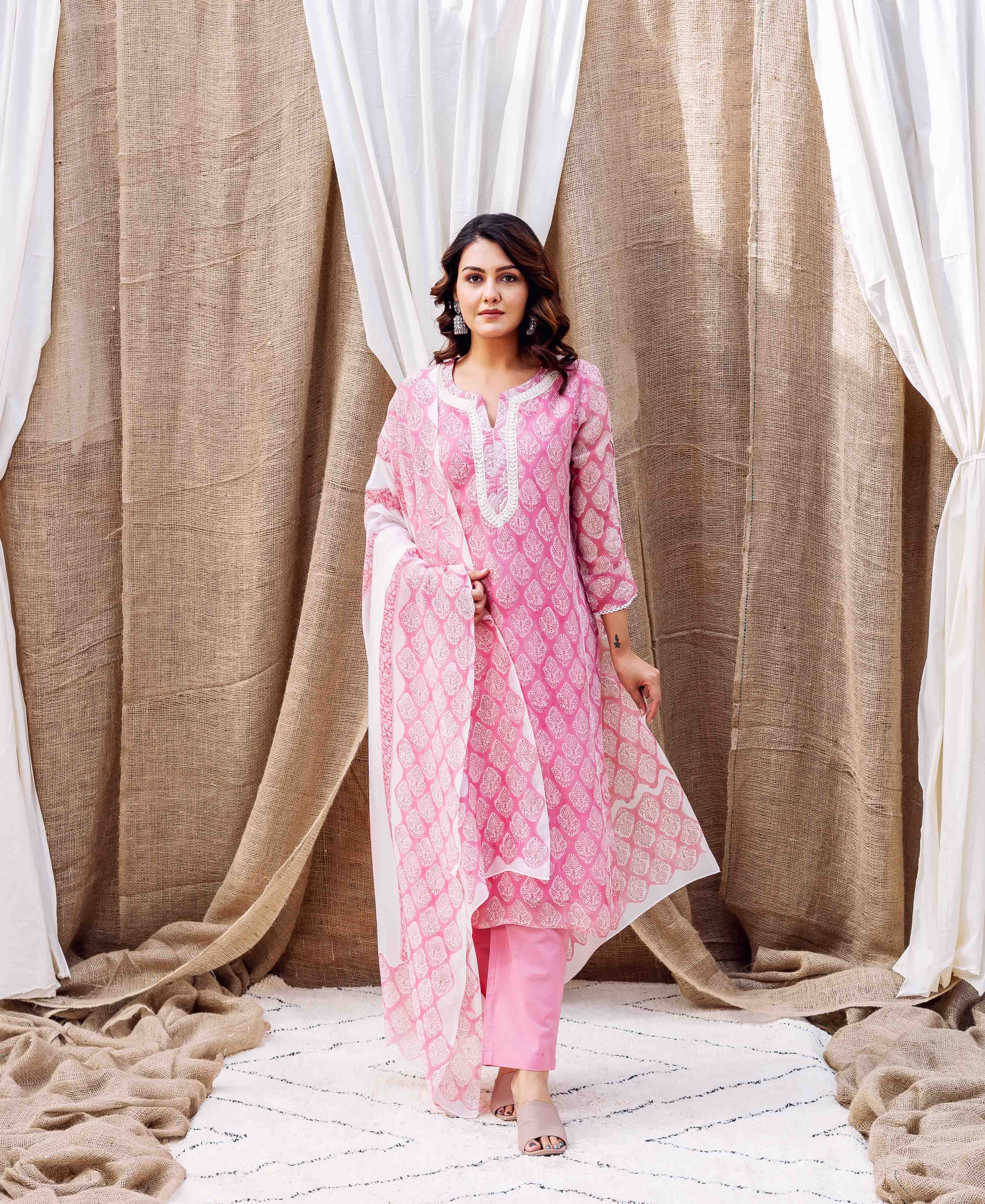 Model wearing blush pink hand-block printed organza kurta set with white pattern.