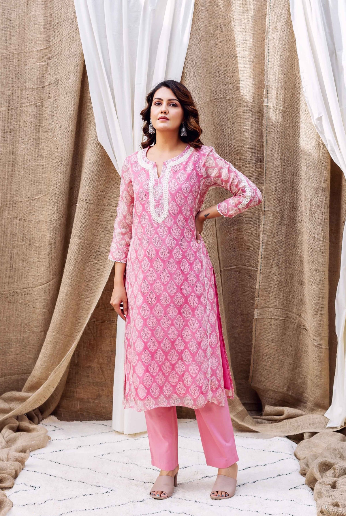 Model wears a blush pink organza kurta with white ethnic print and matching pants.