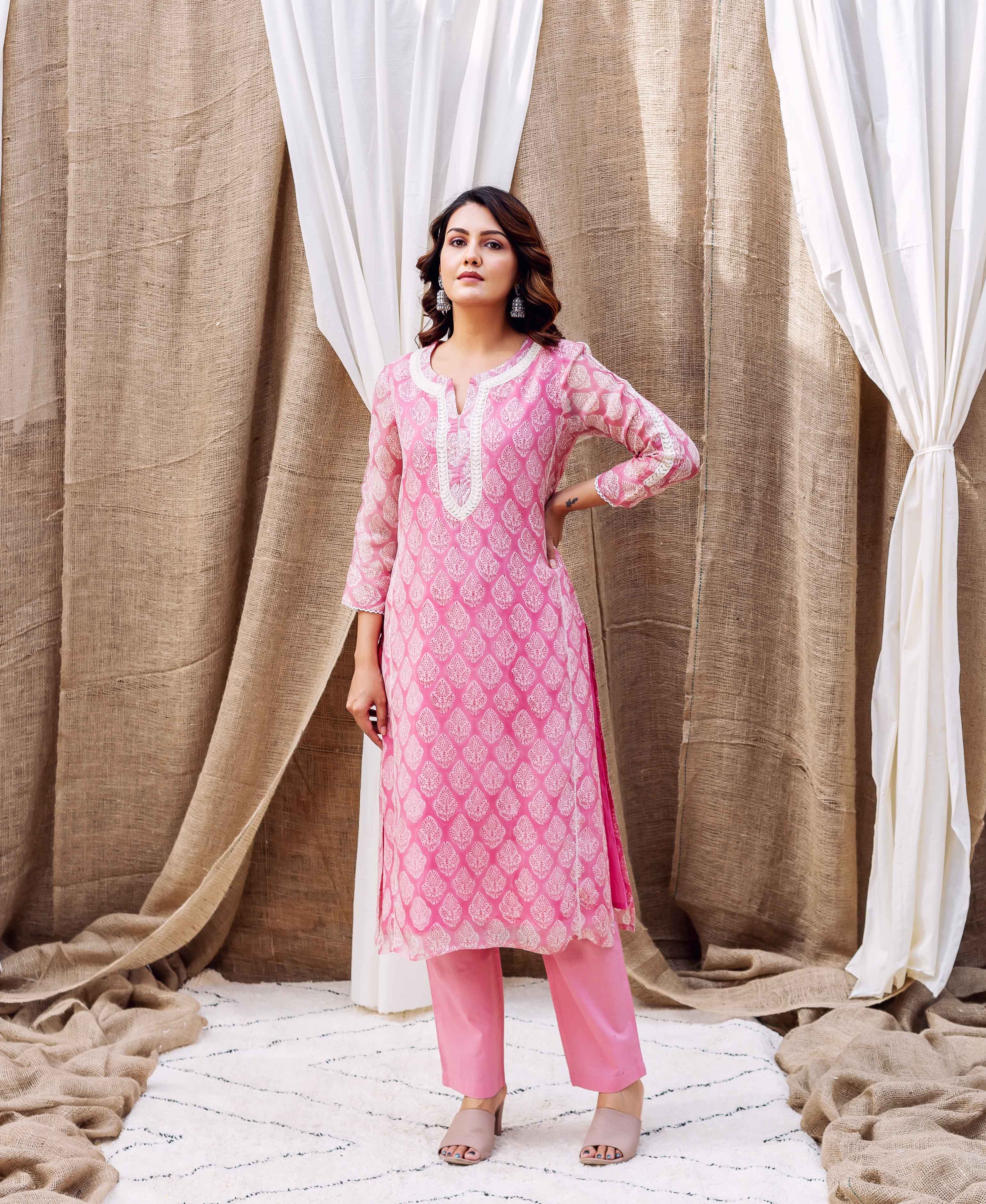Model wears a blush pink organza kurta with white ethnic print and matching pants.