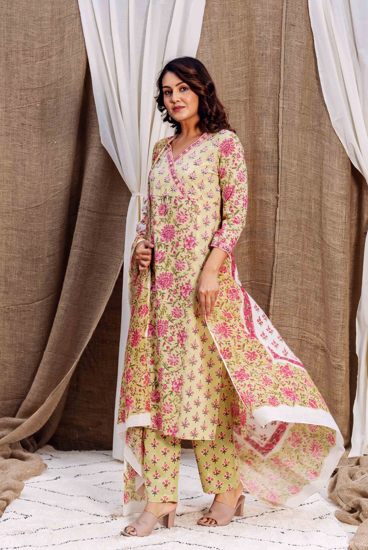 Full-length model wears a light green and pink floral block-printed kurta set.