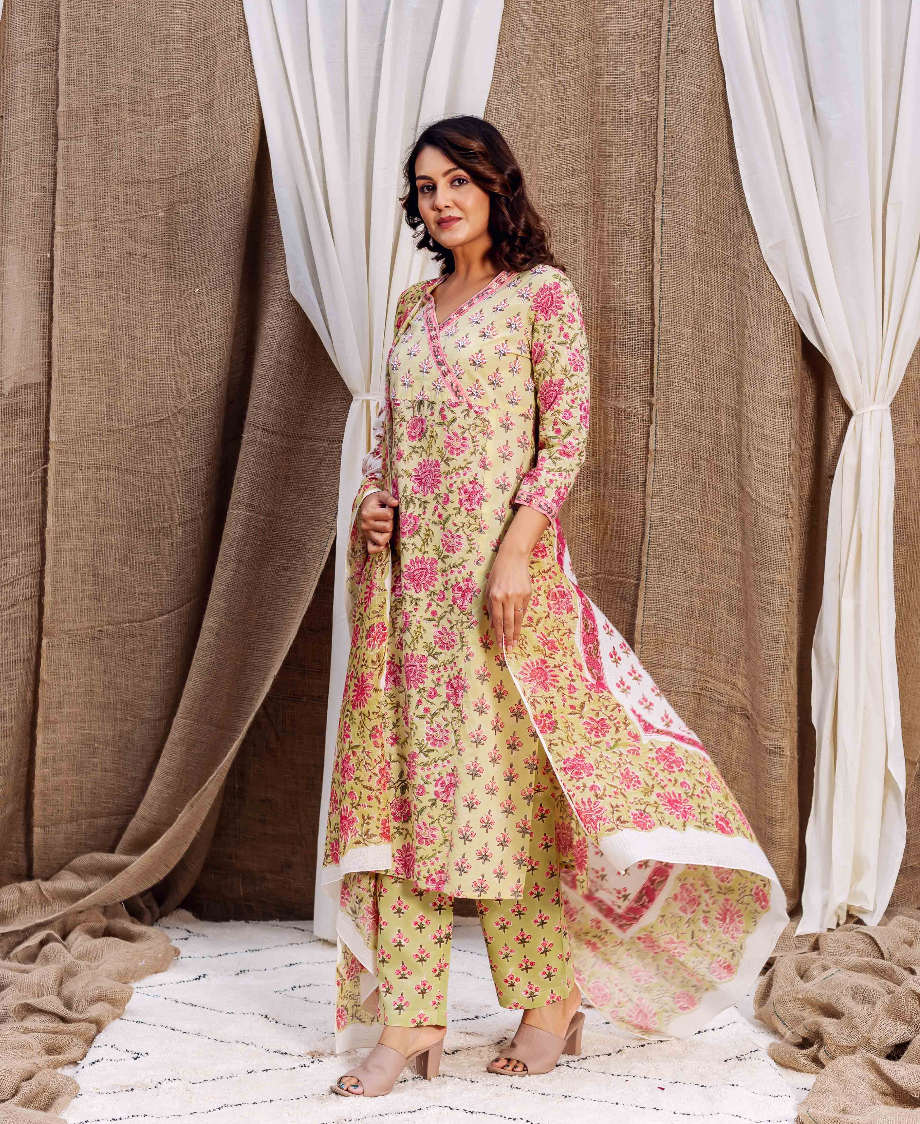 Full-length model wears a light green and pink floral block-printed kurta set.