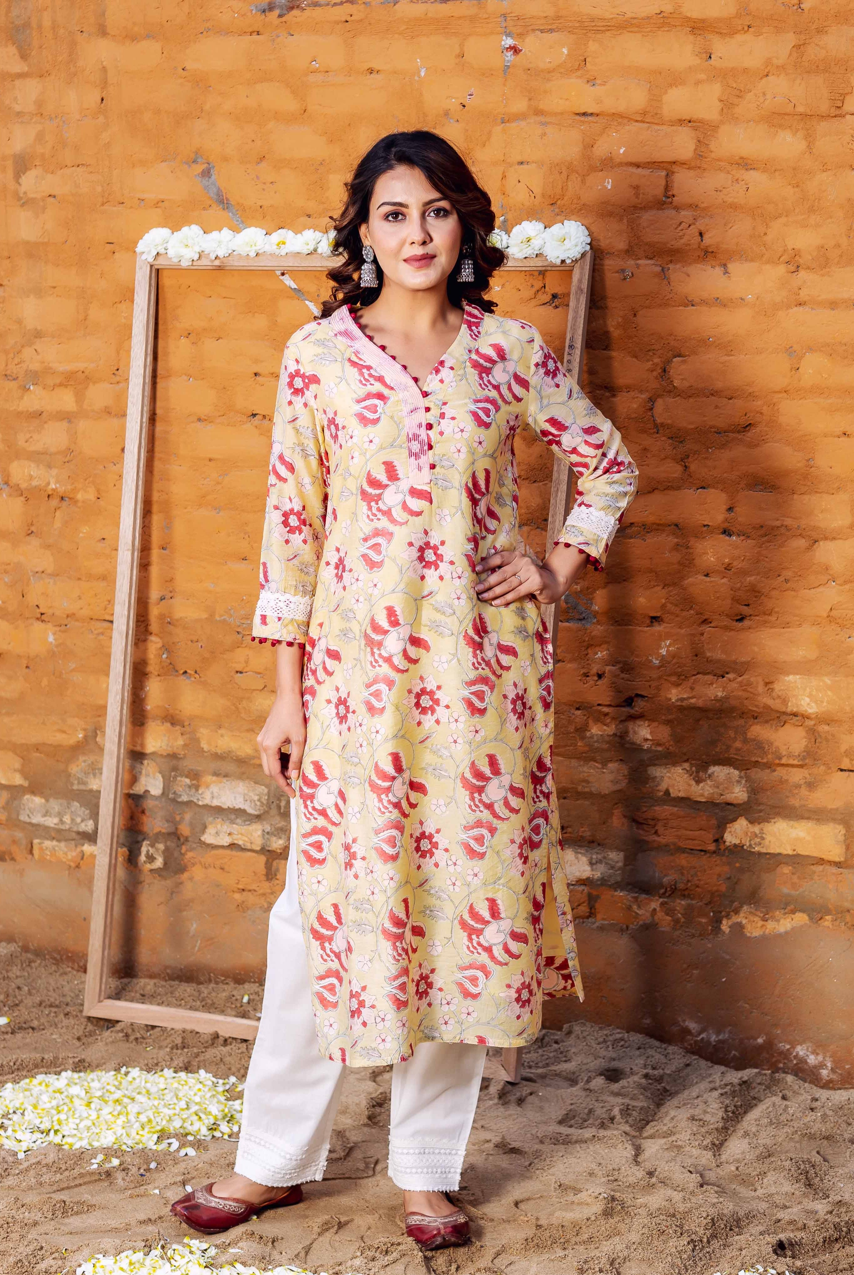 Woman wears yellow Chanderi kurta featuring red blossom hand-block print and white pants.