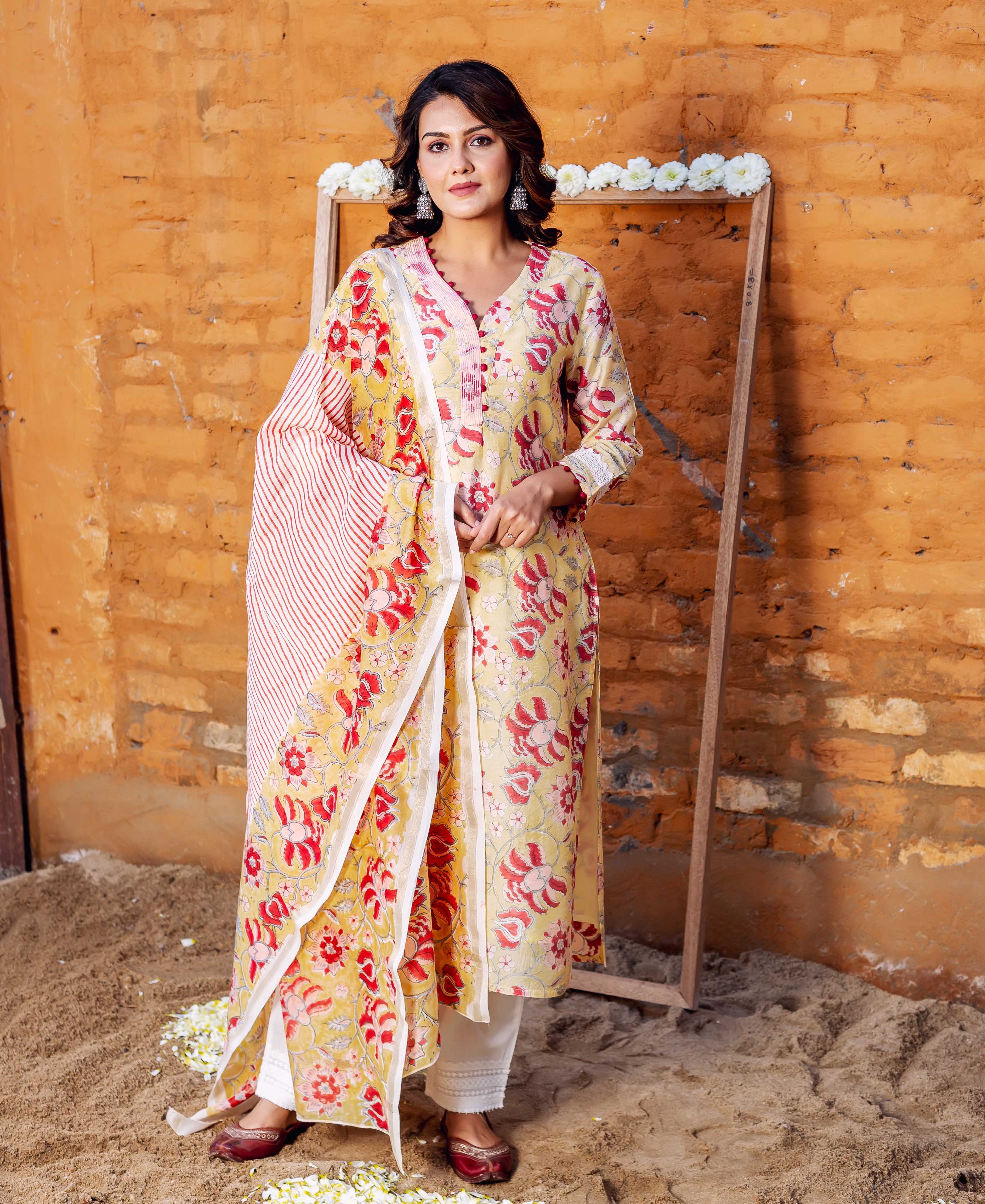 Woman in a yellow floral hand-block printed kurta set and red striped dupatta.