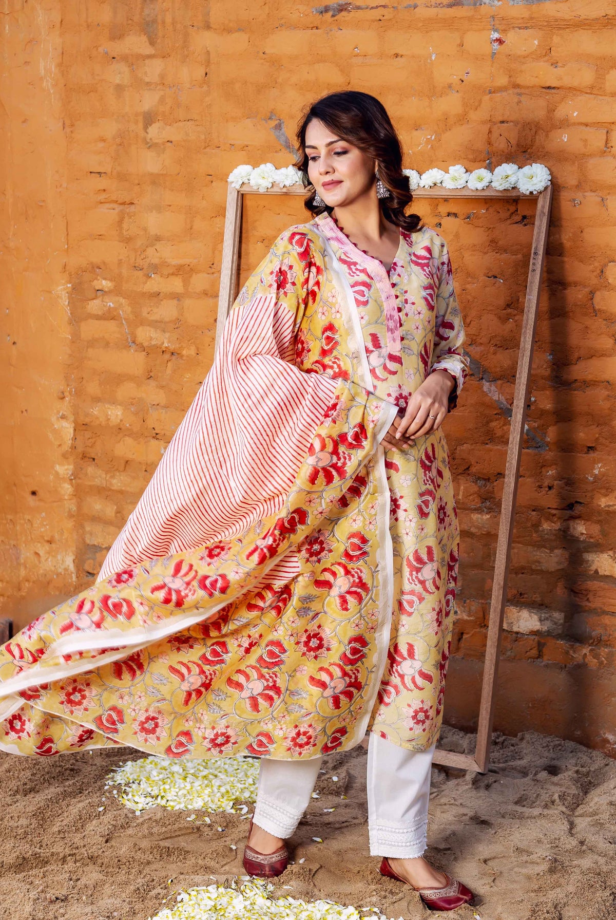 Model in yellow floral hand-block printed Chanderi kurta with flowing red striped dupatta.