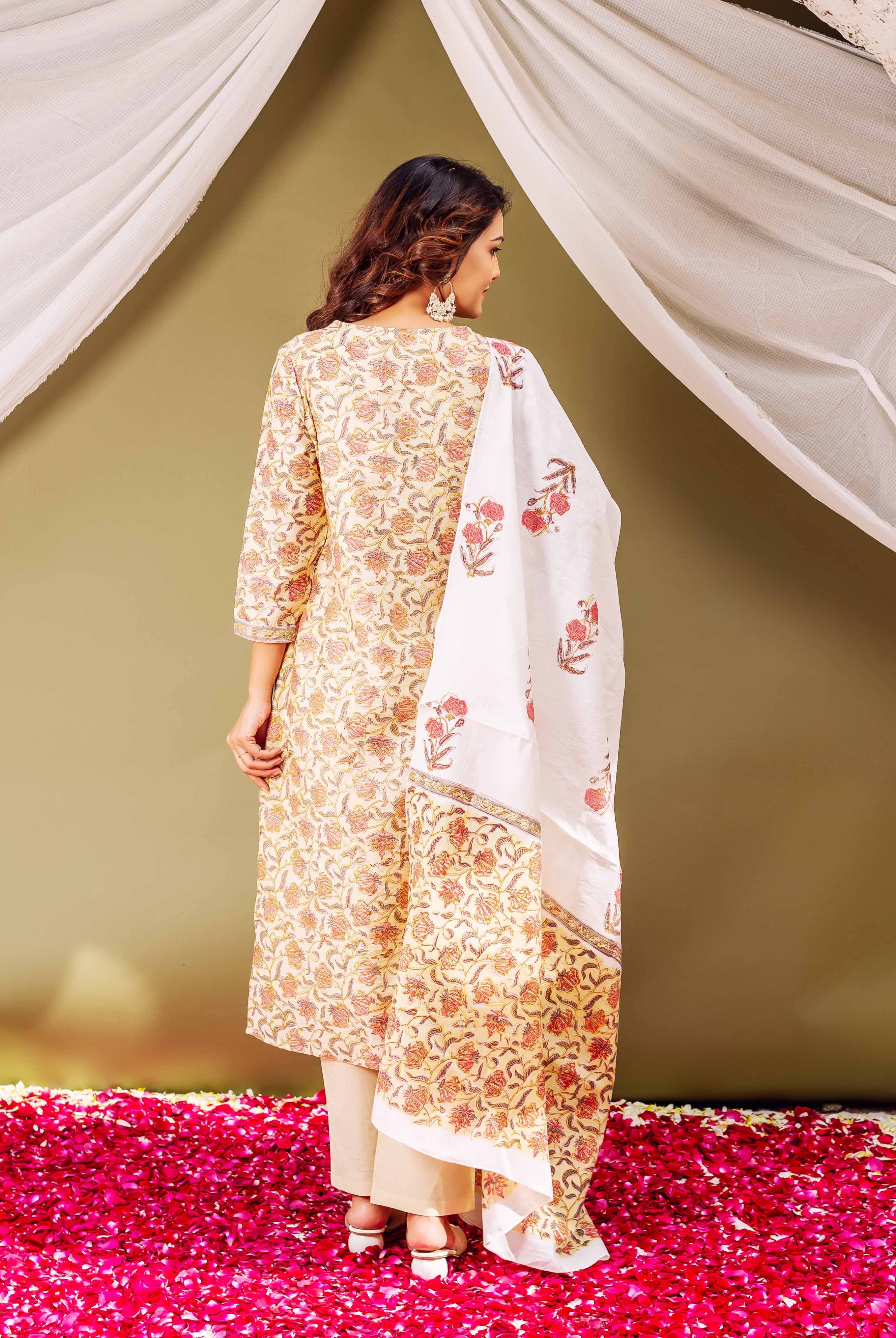 A woman in a green floral block print kurta with a white dupatta.