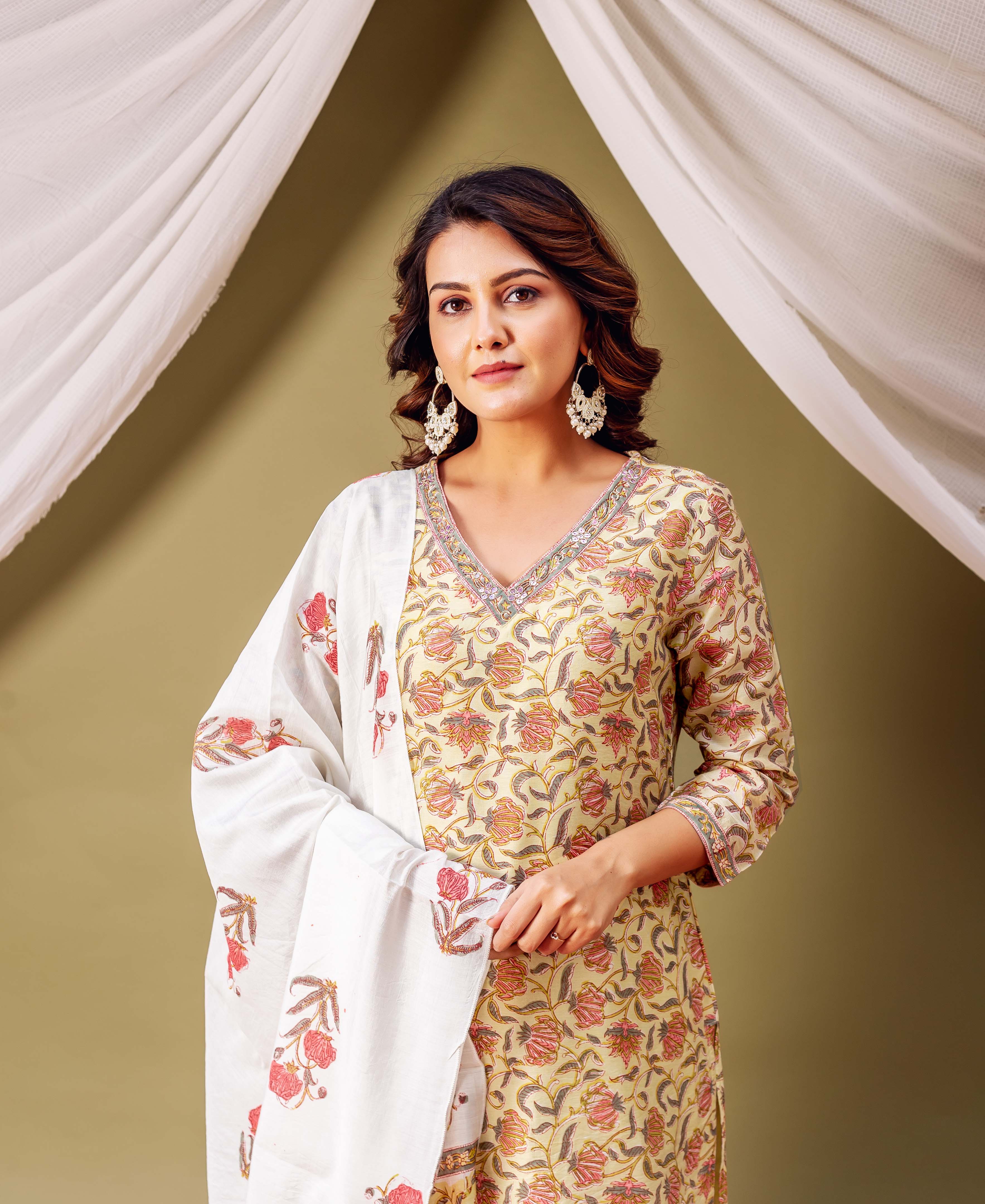 Front view of model in cream floral print kurta and white jaal print dupatta.