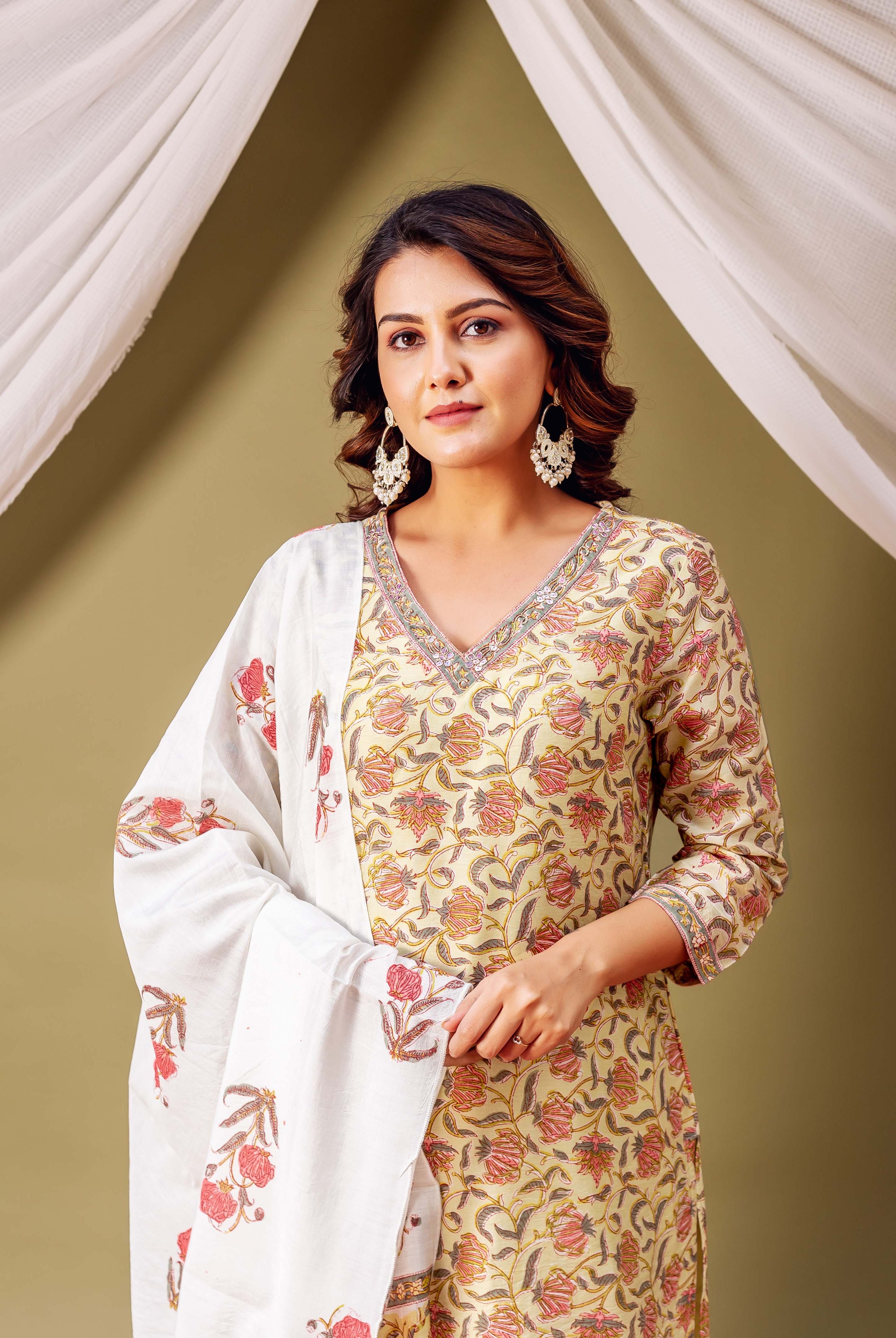 A woman in a green floral kurta with a white dupatta.