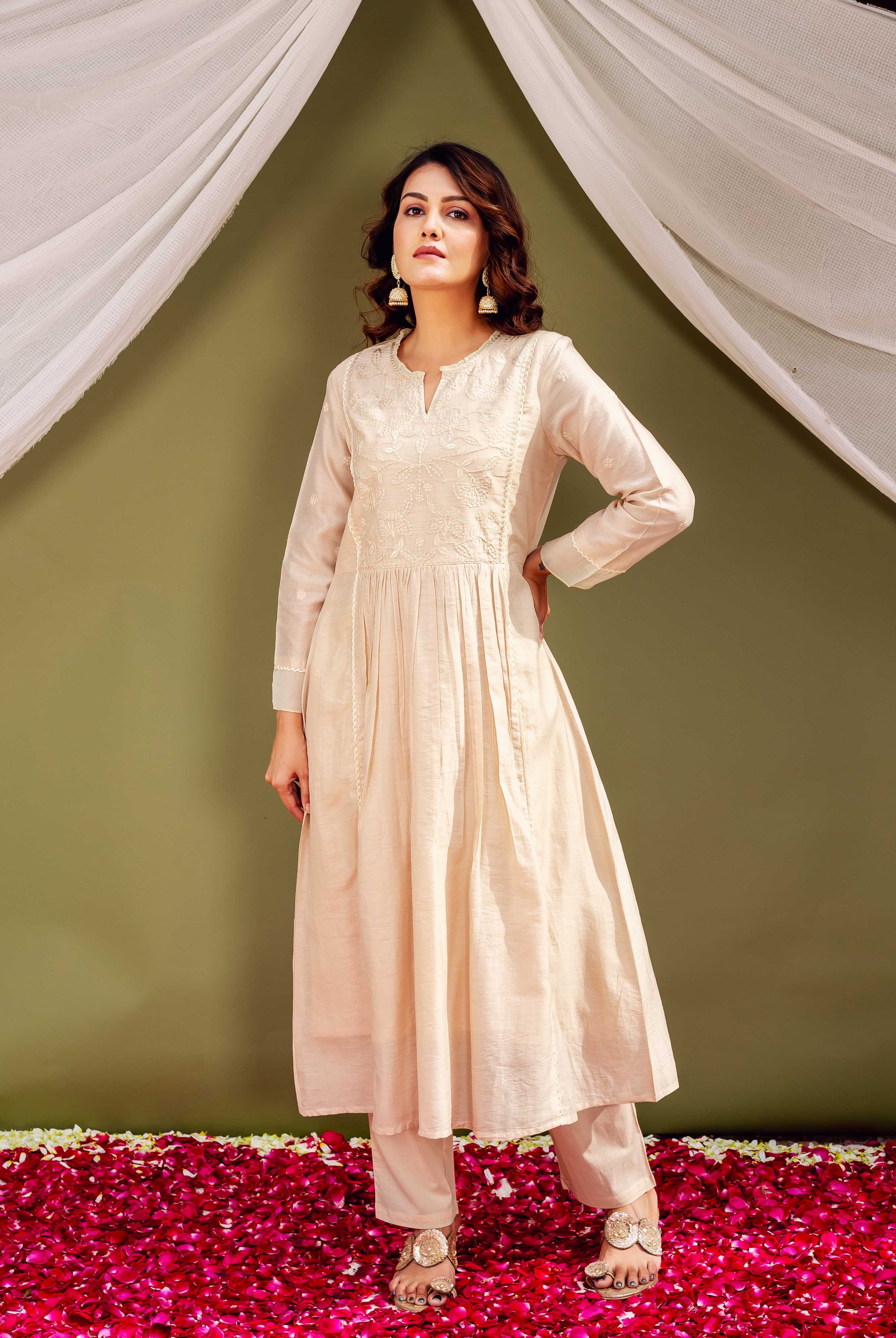 Full-length shot of a female model wearing a sandstone Chanderi kurta with intricate white embroidery.