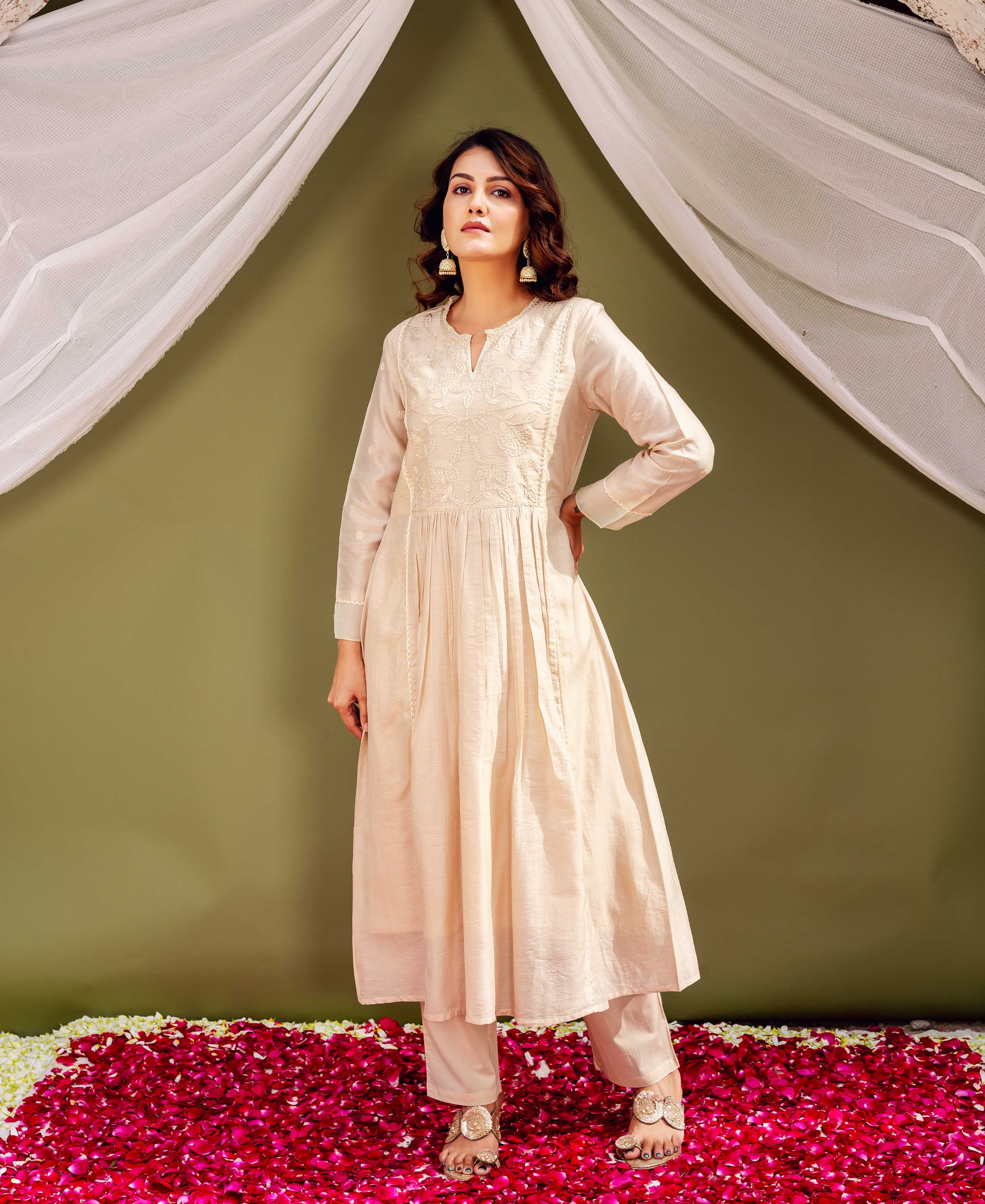 Full-length shot of a female model wearing a sandstone Chanderi kurta with intricate white embroidery.