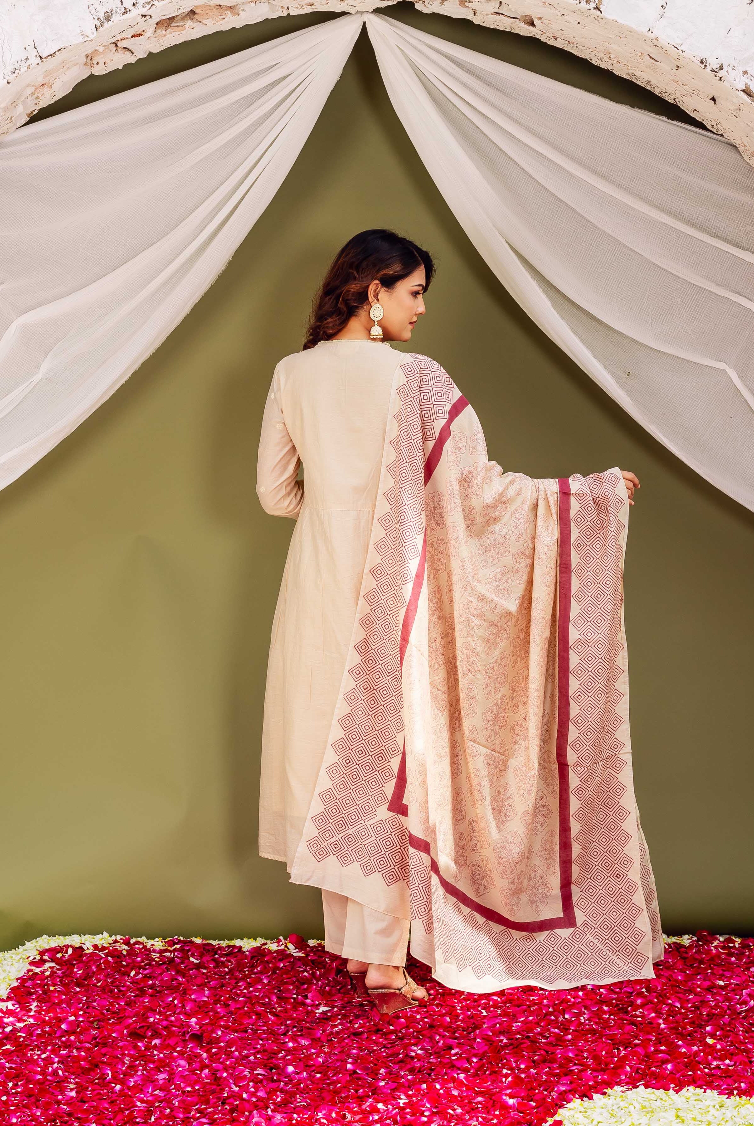 Back view of model in cream kurta set with geometric maroon block-printed dupatta.