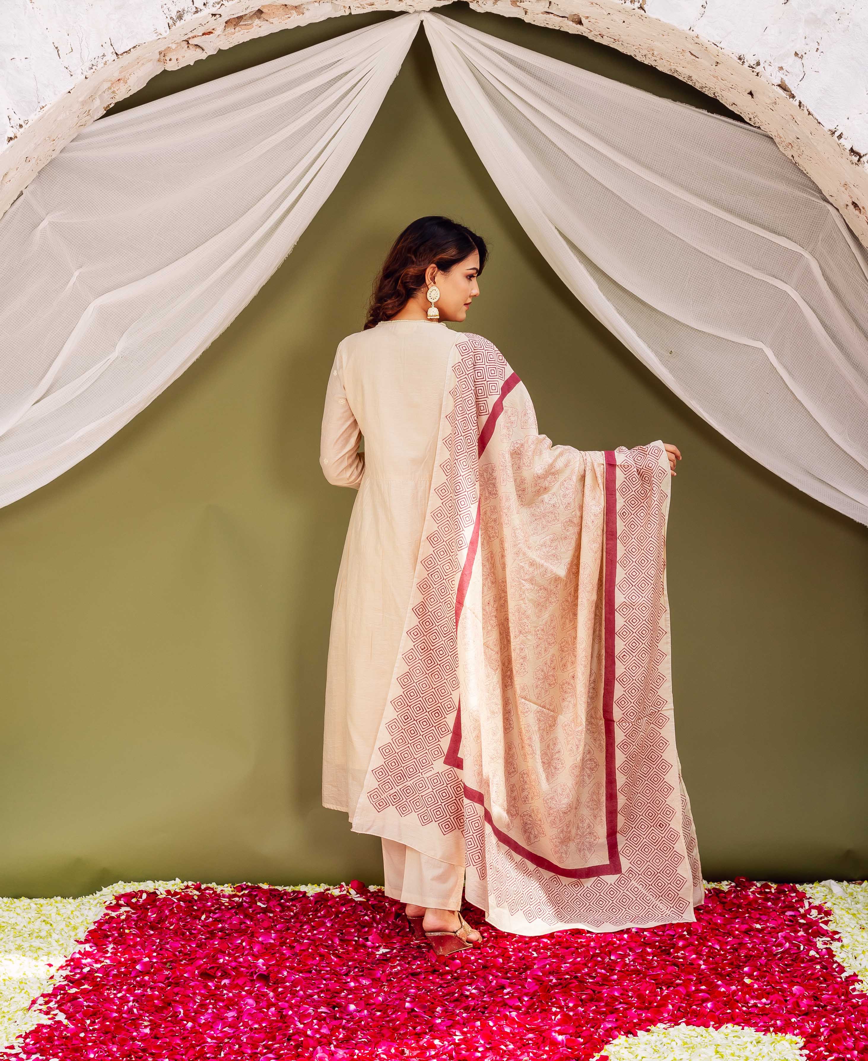 Back view of model in cream kurta set with geometric maroon block-printed dupatta.