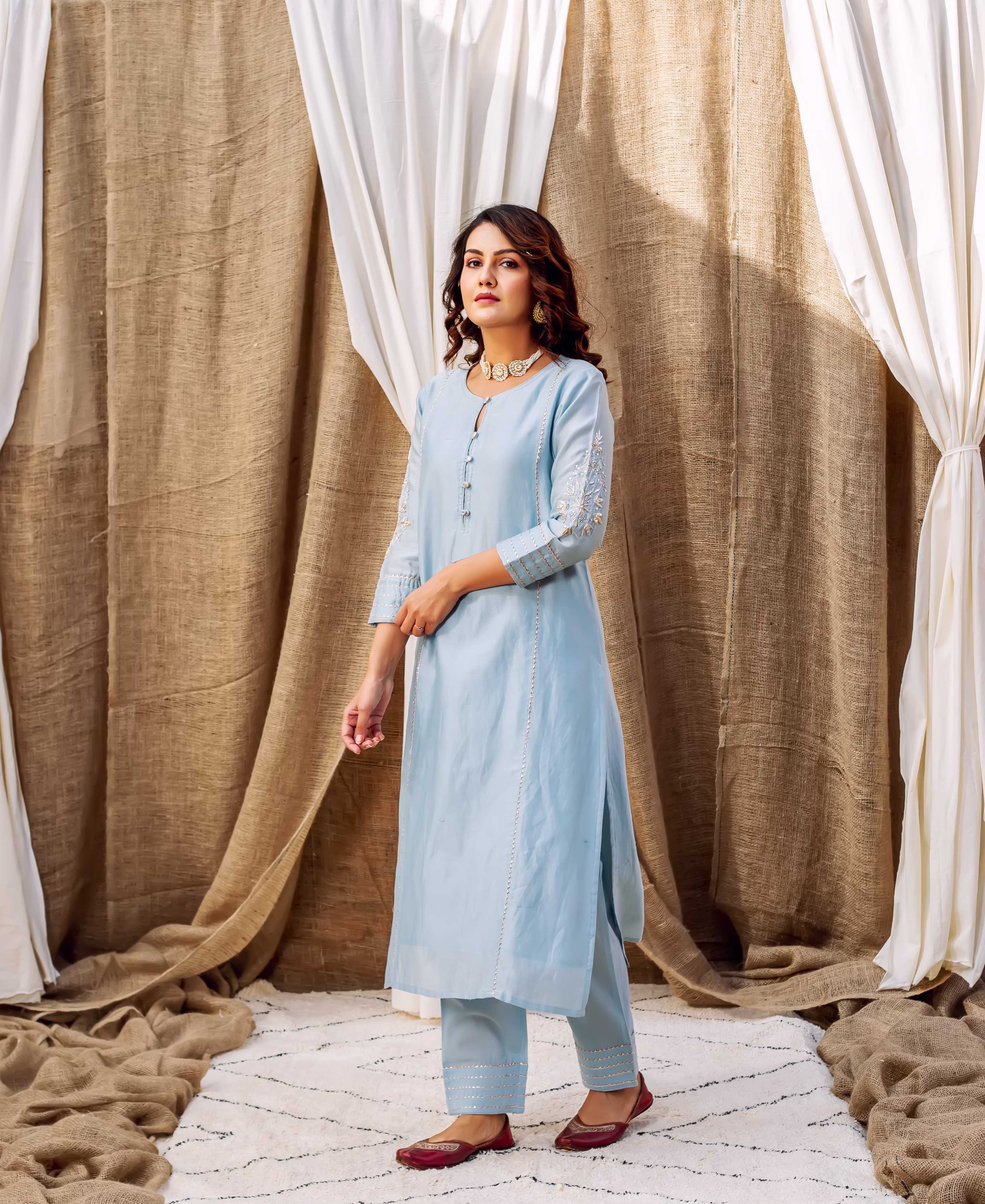Front view of model in azure ethnic kurta set with silver embellishments.