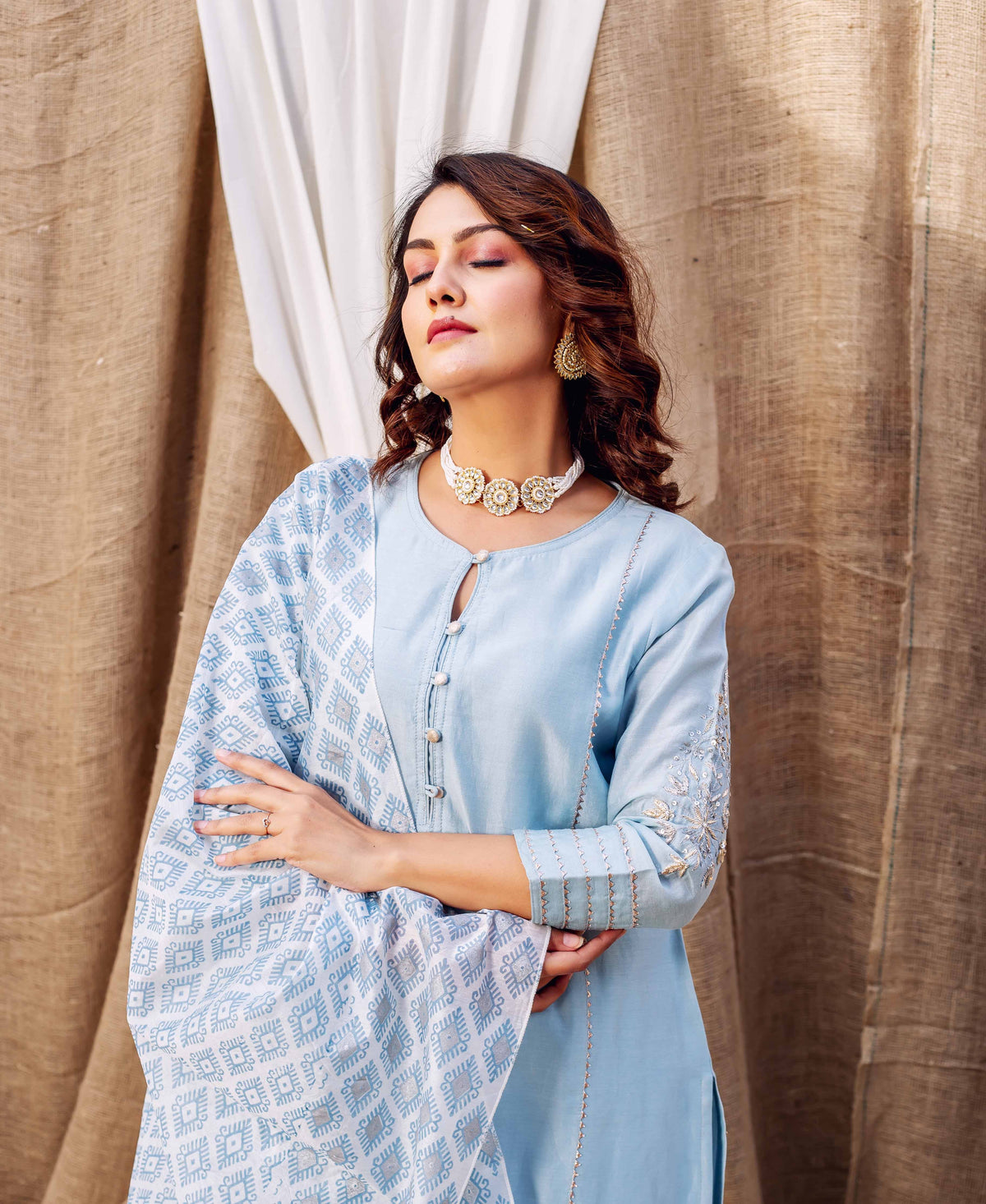 Model wearing an azure kurta with intricate sleeve embroidery and geometric block print dupatta.