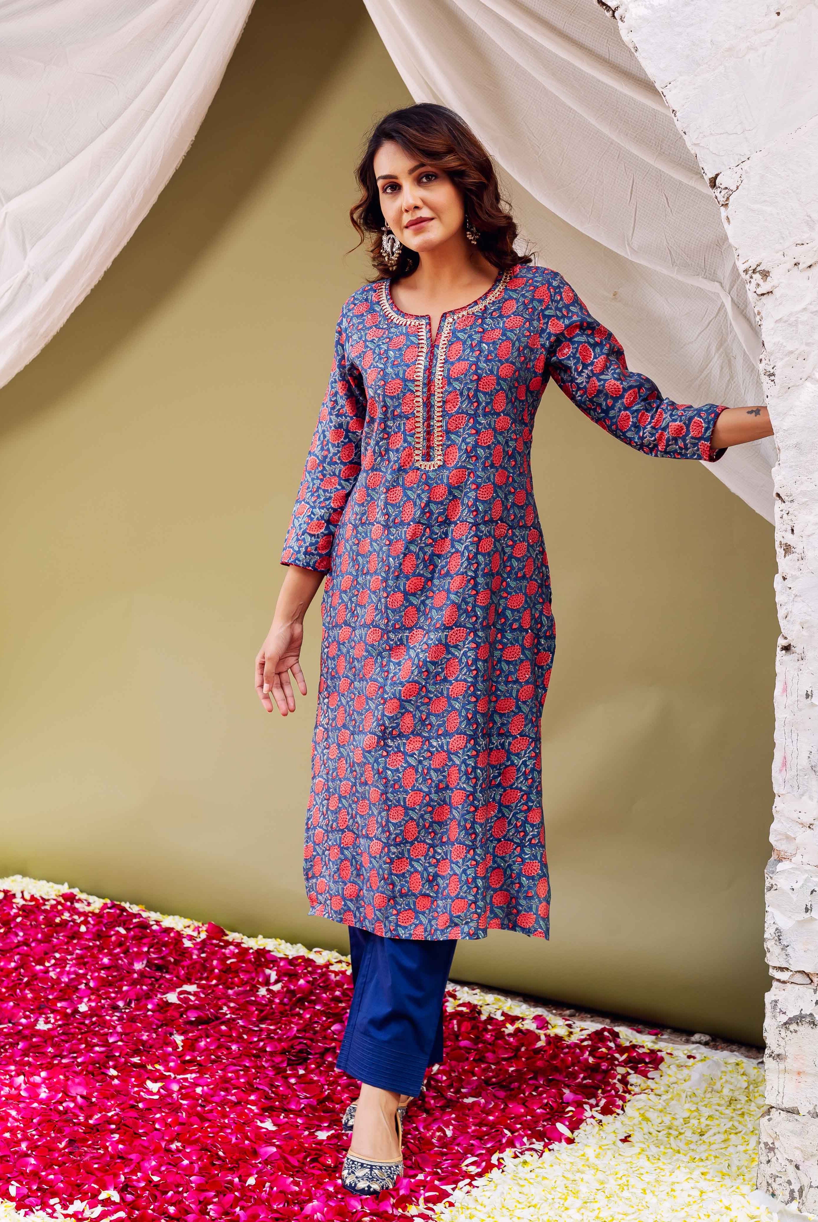 Woman in blue floral hand-block printed kurta with Gota neckline and blue trousers.