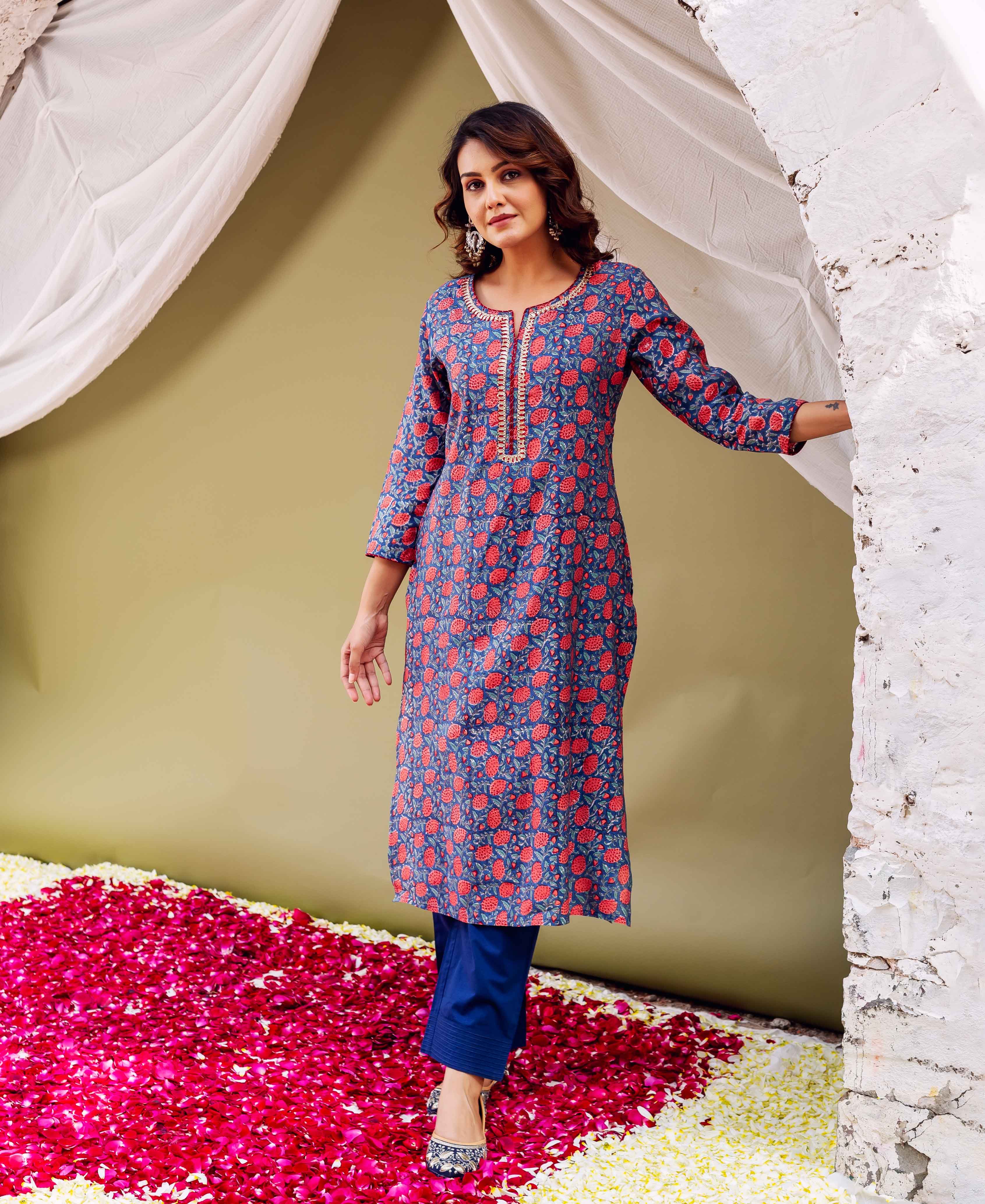 Woman in blue floral hand-block printed kurta with Gota neckline and blue trousers.