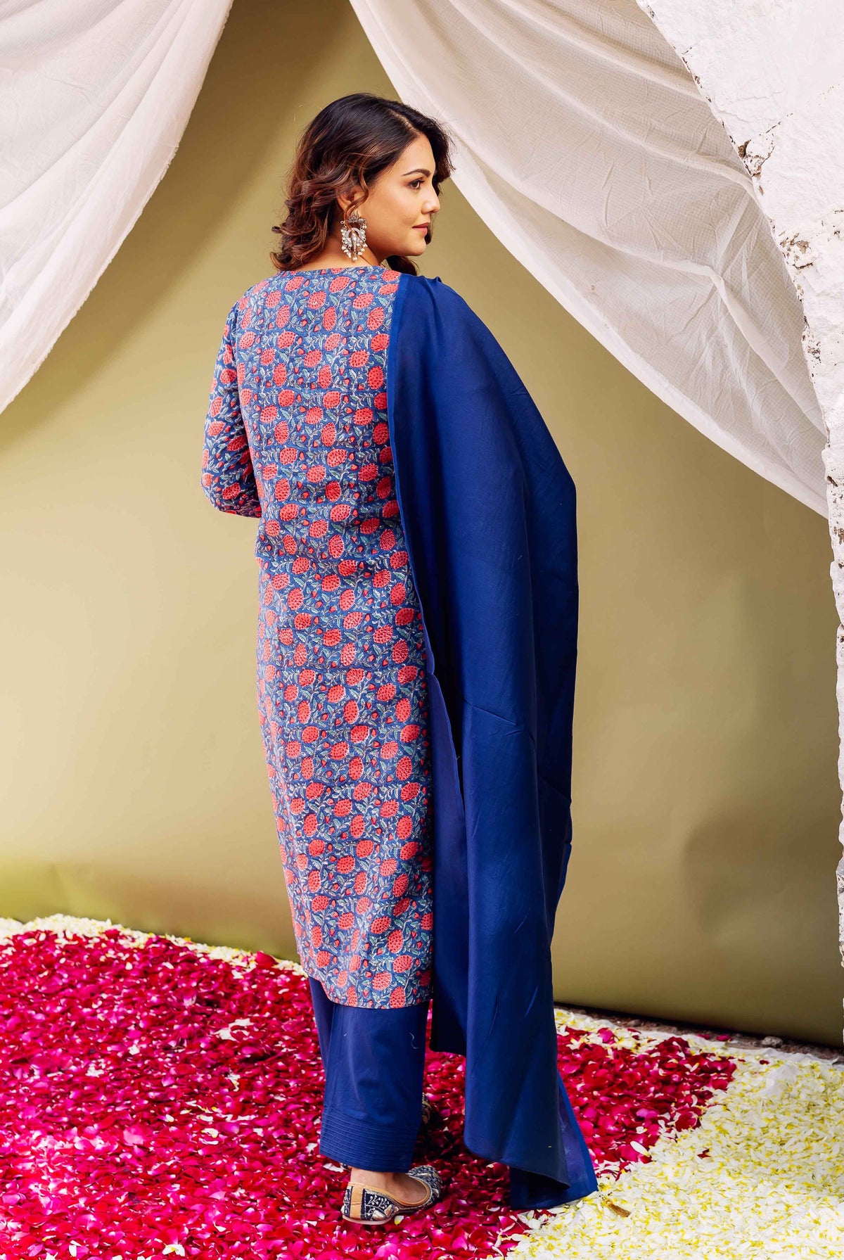 A woman in a blue kurta with red floral print and matching dupatta.