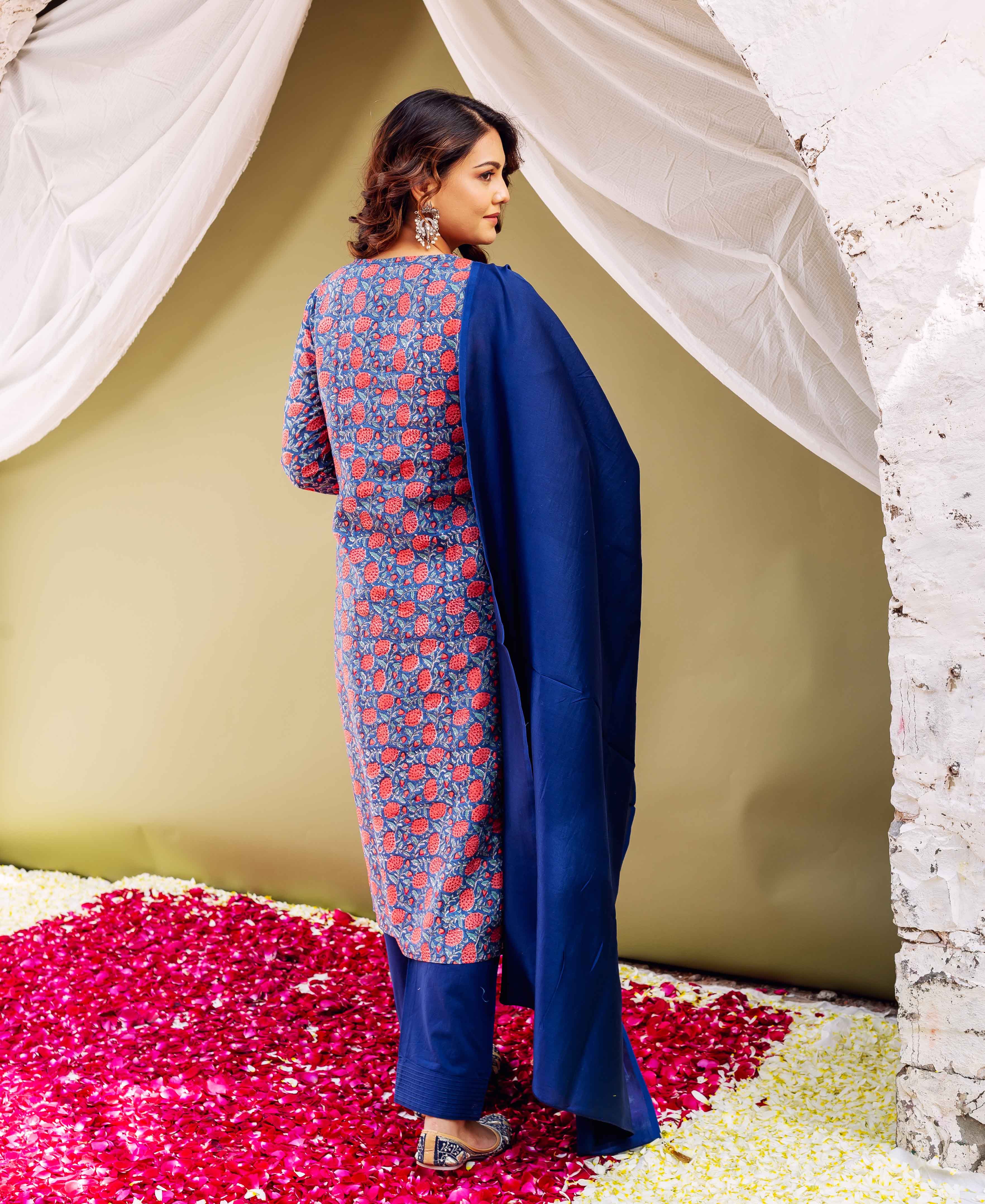 A woman in a blue kurta with red floral print and matching dupatta.