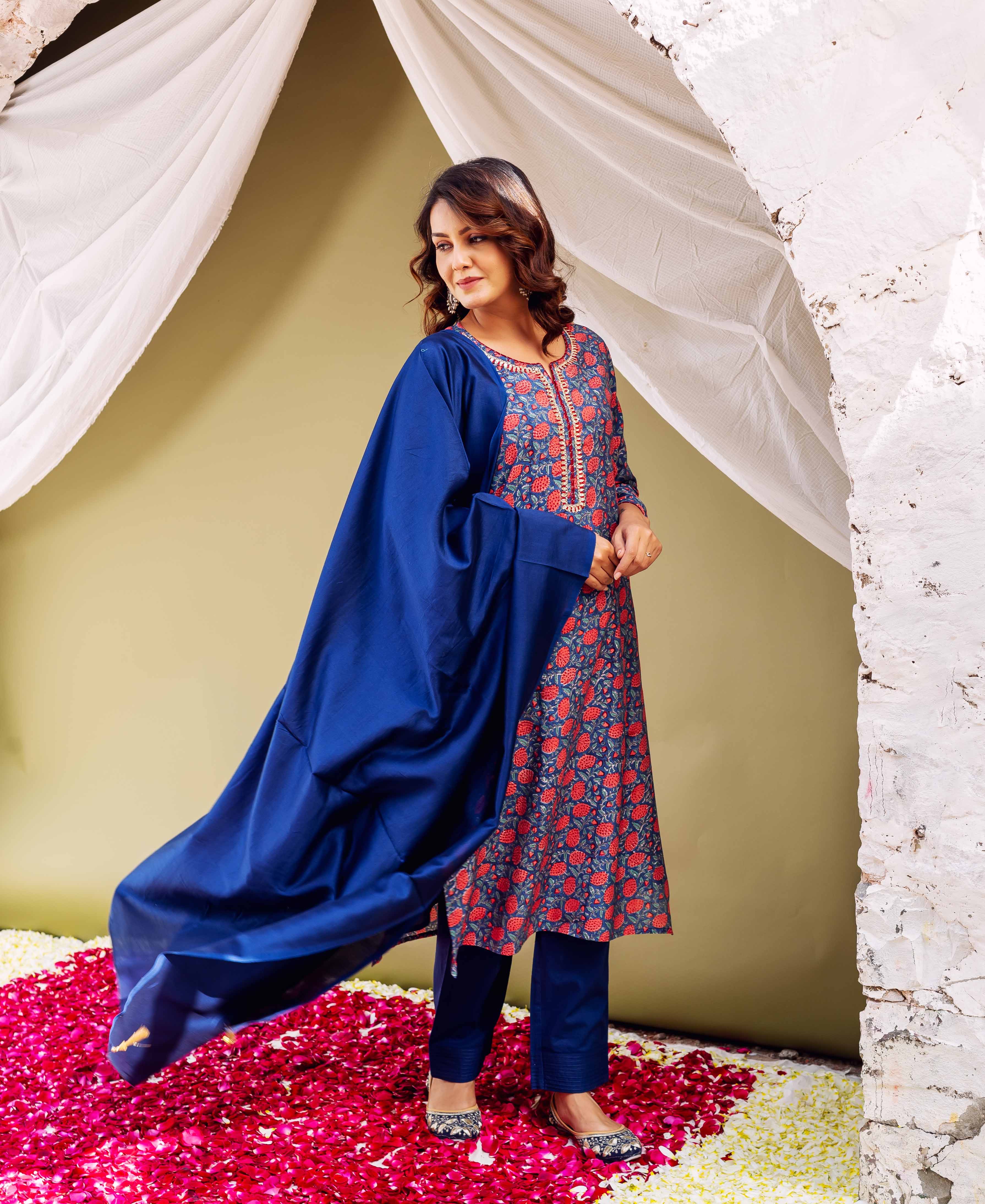 Model in blue hand-block-printed kurta with red floral print, matching pants, and dupatta.