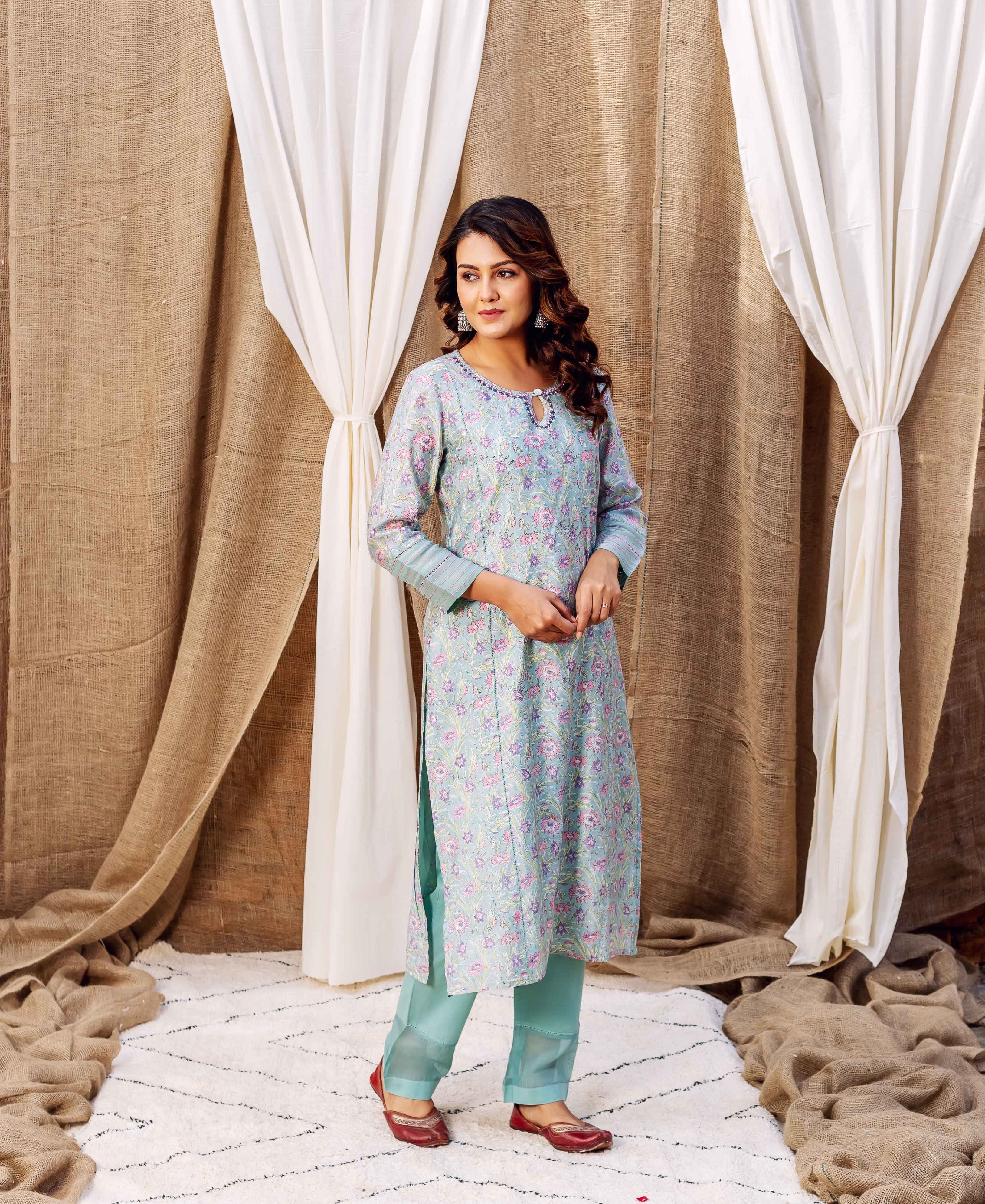 Front view of model in a sea green hand-block-printed floral kurta and matching pants.