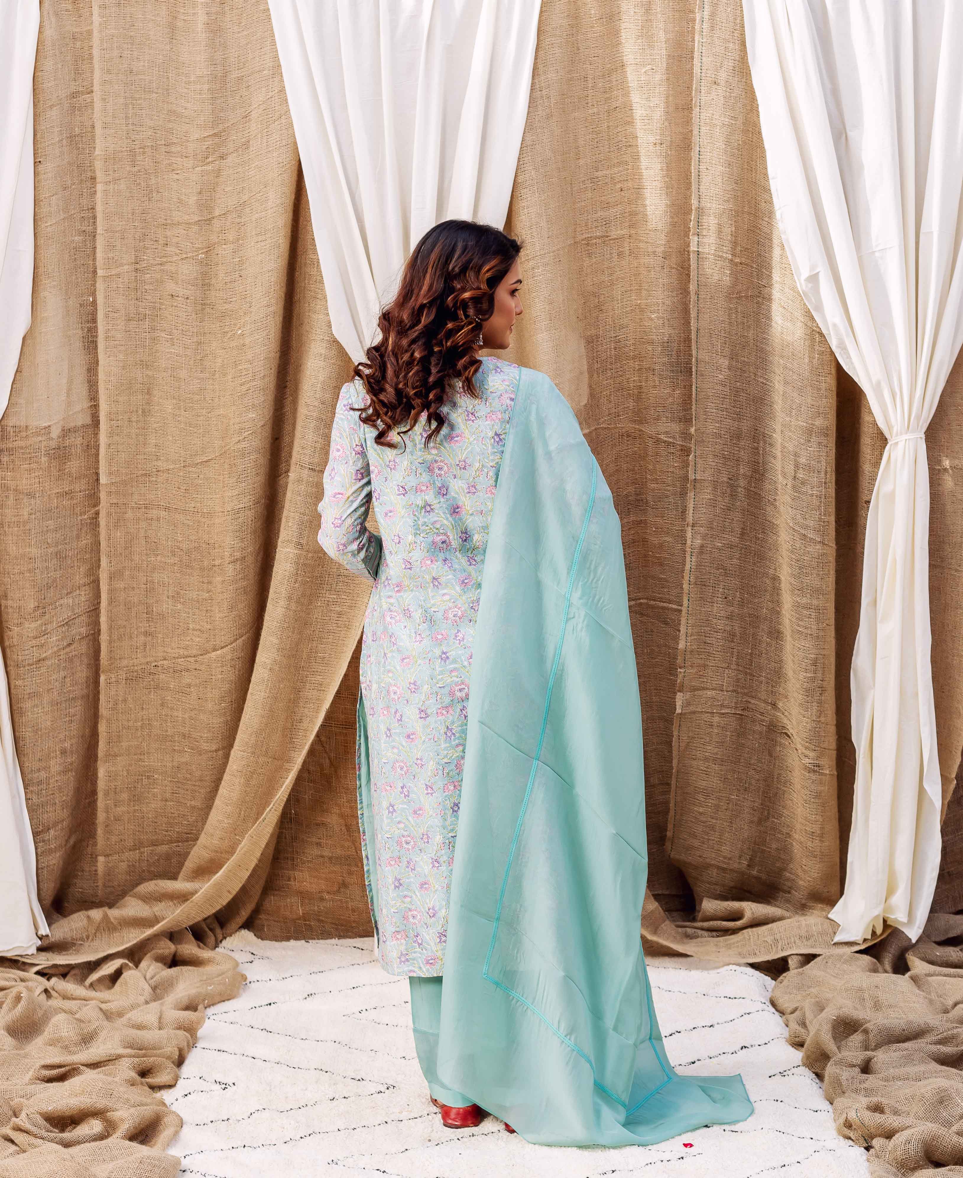 Back view of model in sea green hand-block-printed floral kurta set with dupatta.