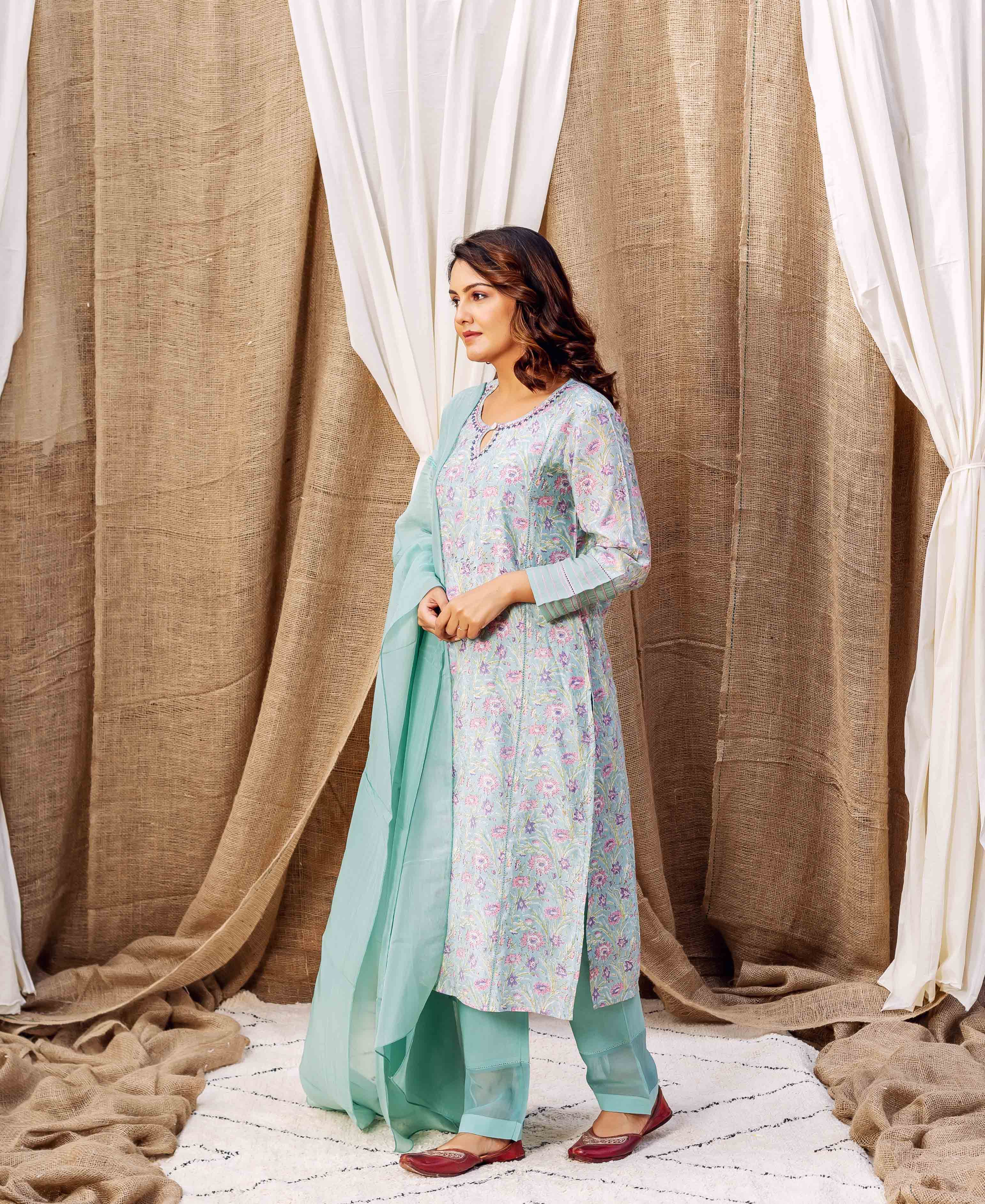 Side view of model in sea green hand-printed floral kurta and matching dupatta.