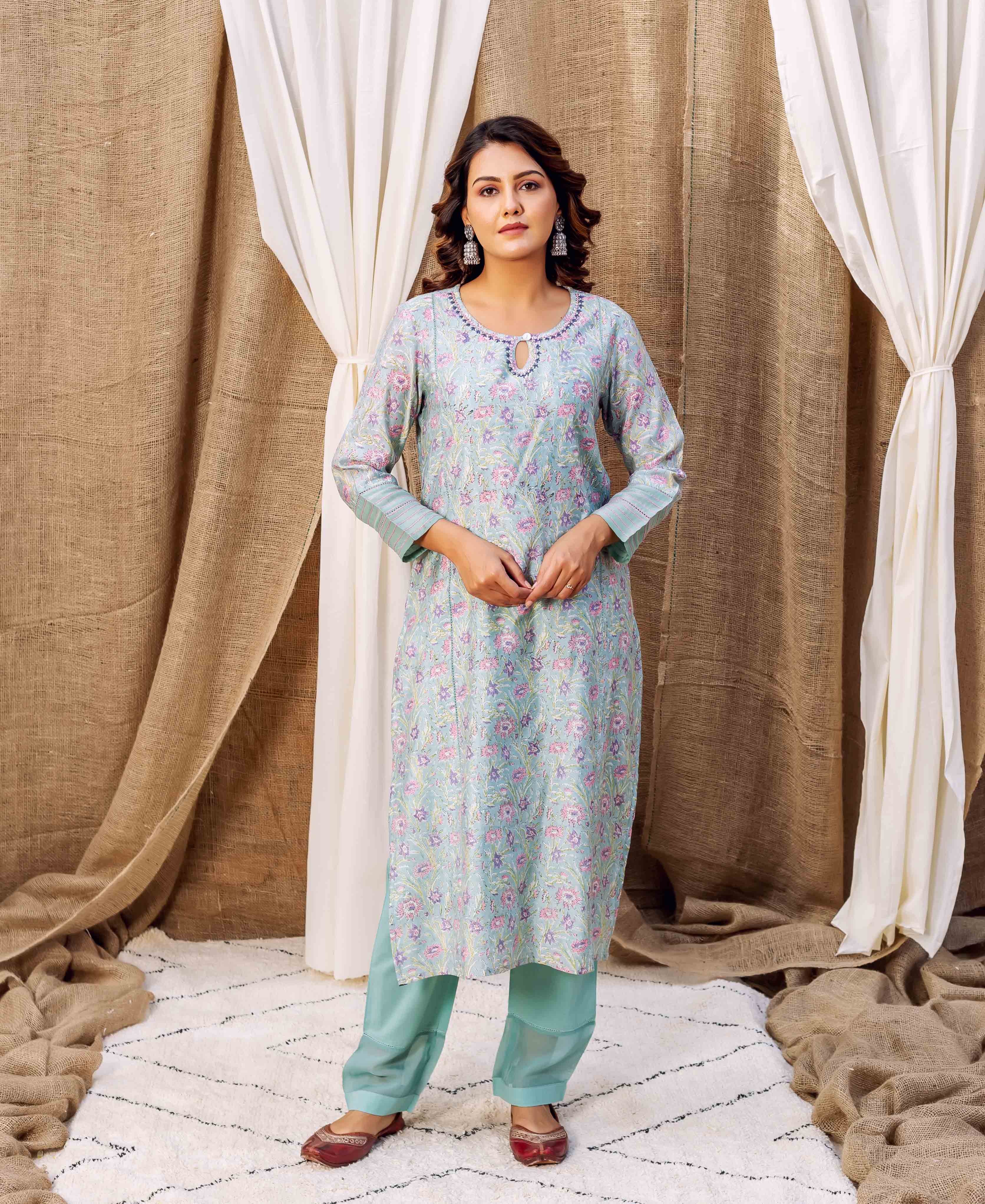 Front view of a model in a sea green hand-printed floral kurta and matching pants.