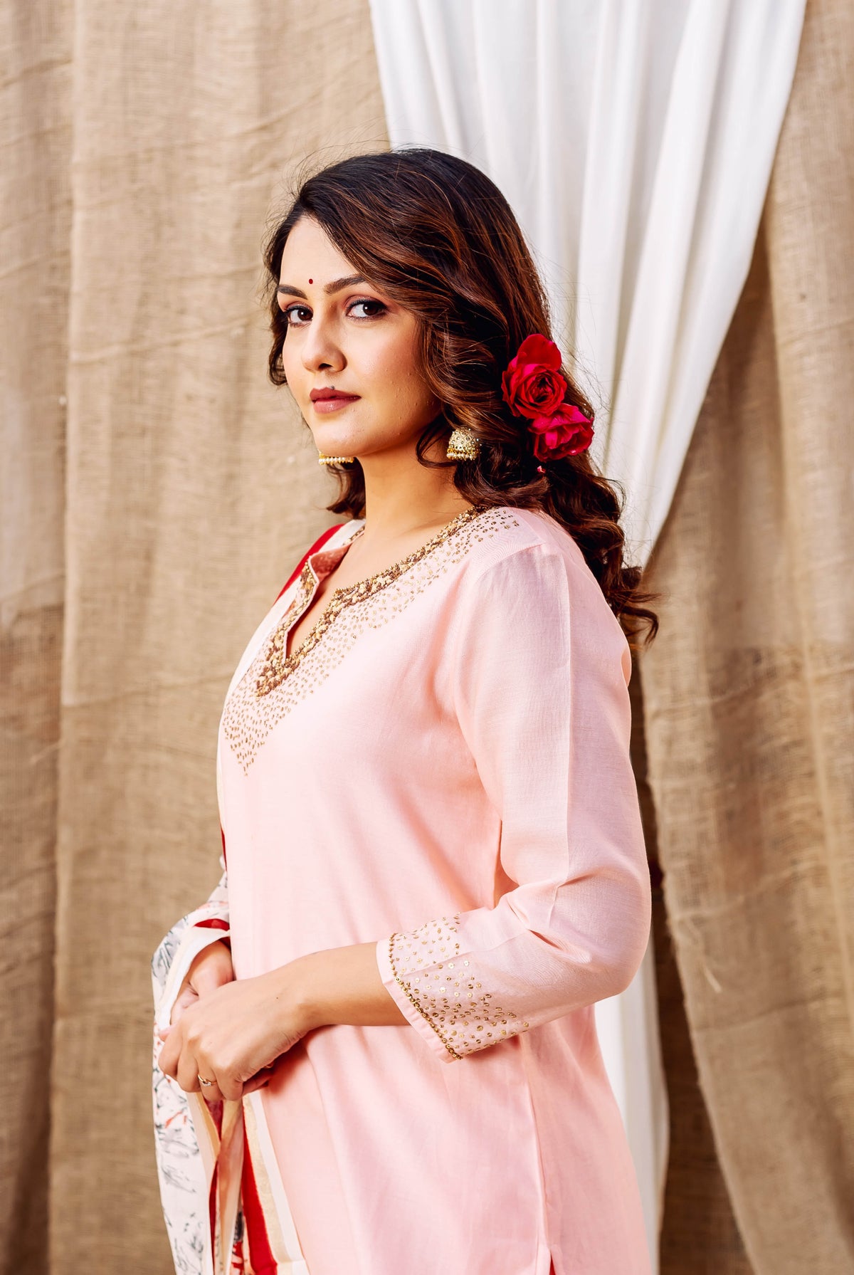 Model wearing light pink ethnic kurta with hand-block printed gold patterns on neckline.