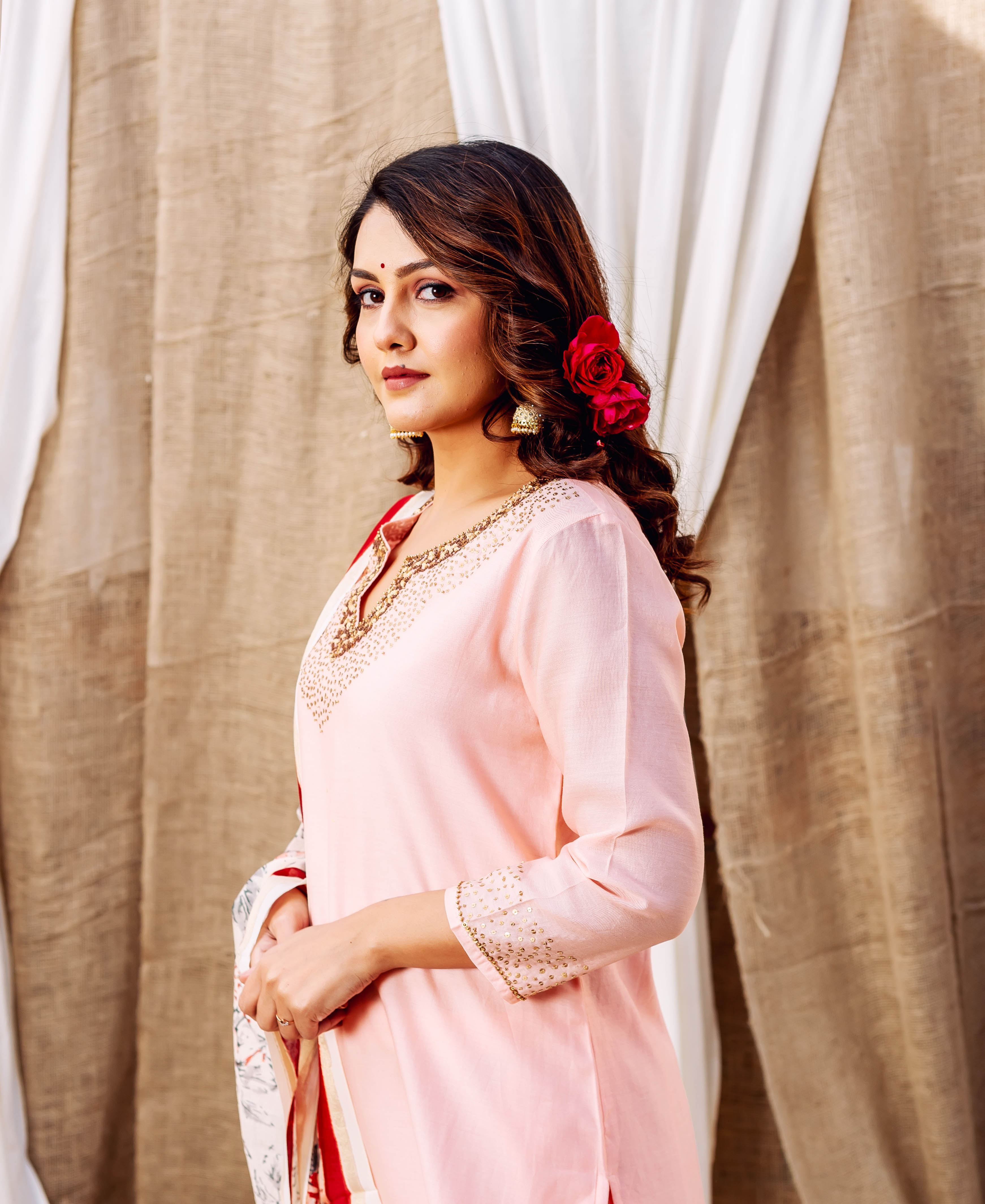Model wearing light pink ethnic kurta with hand-block printed gold patterns on neckline.
