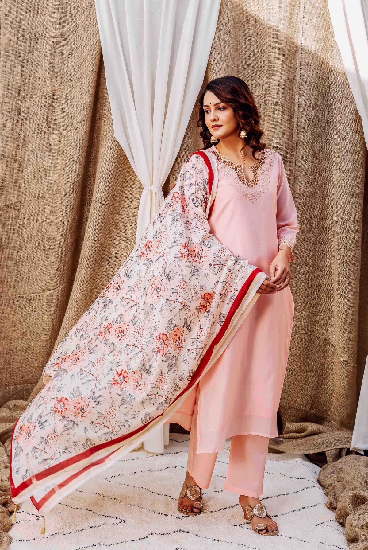 Full shot of model in rose-pink kurta set and a white floral printed dupatta.