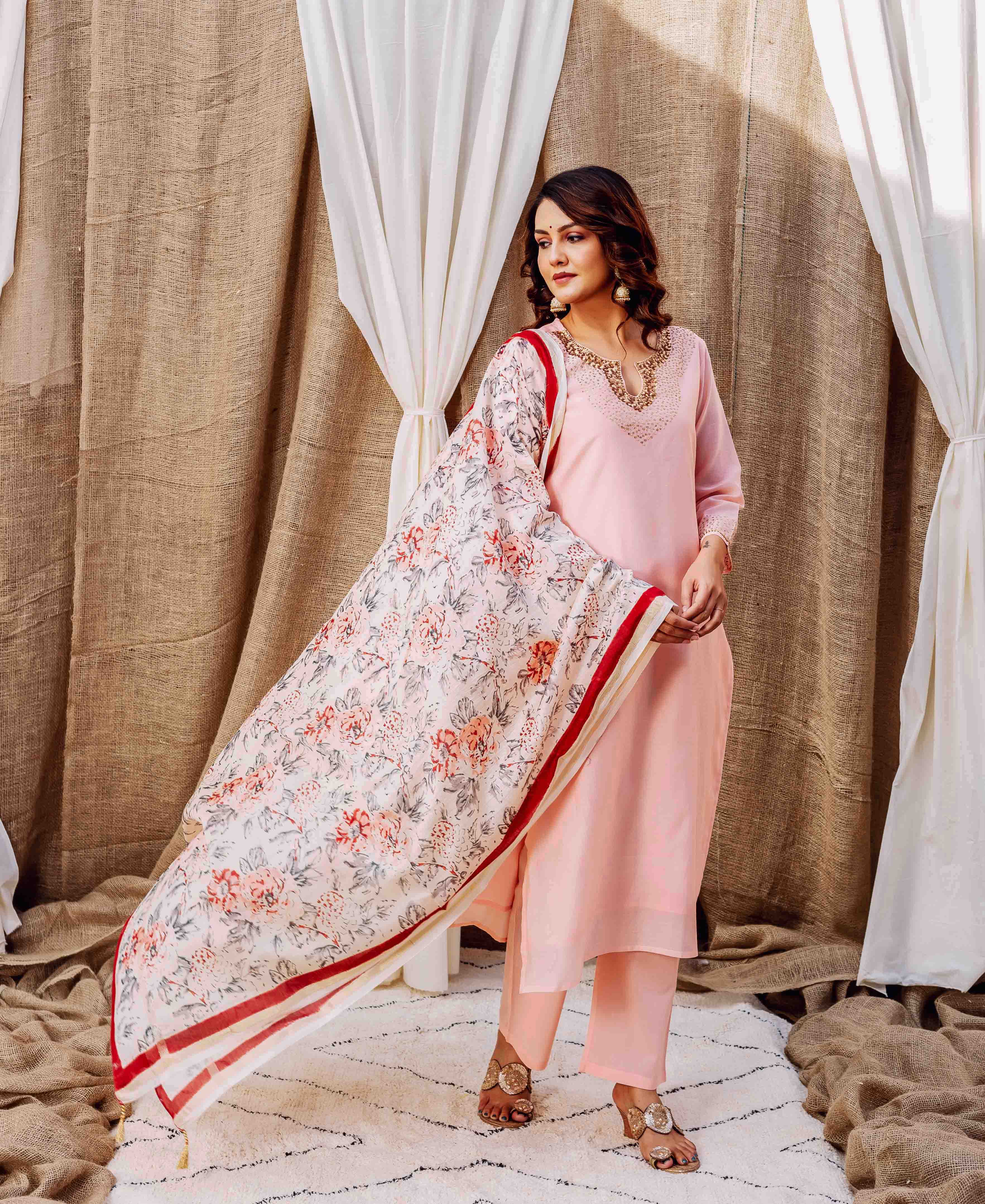 Full shot of model in rose-pink kurta set and a white floral printed dupatta.