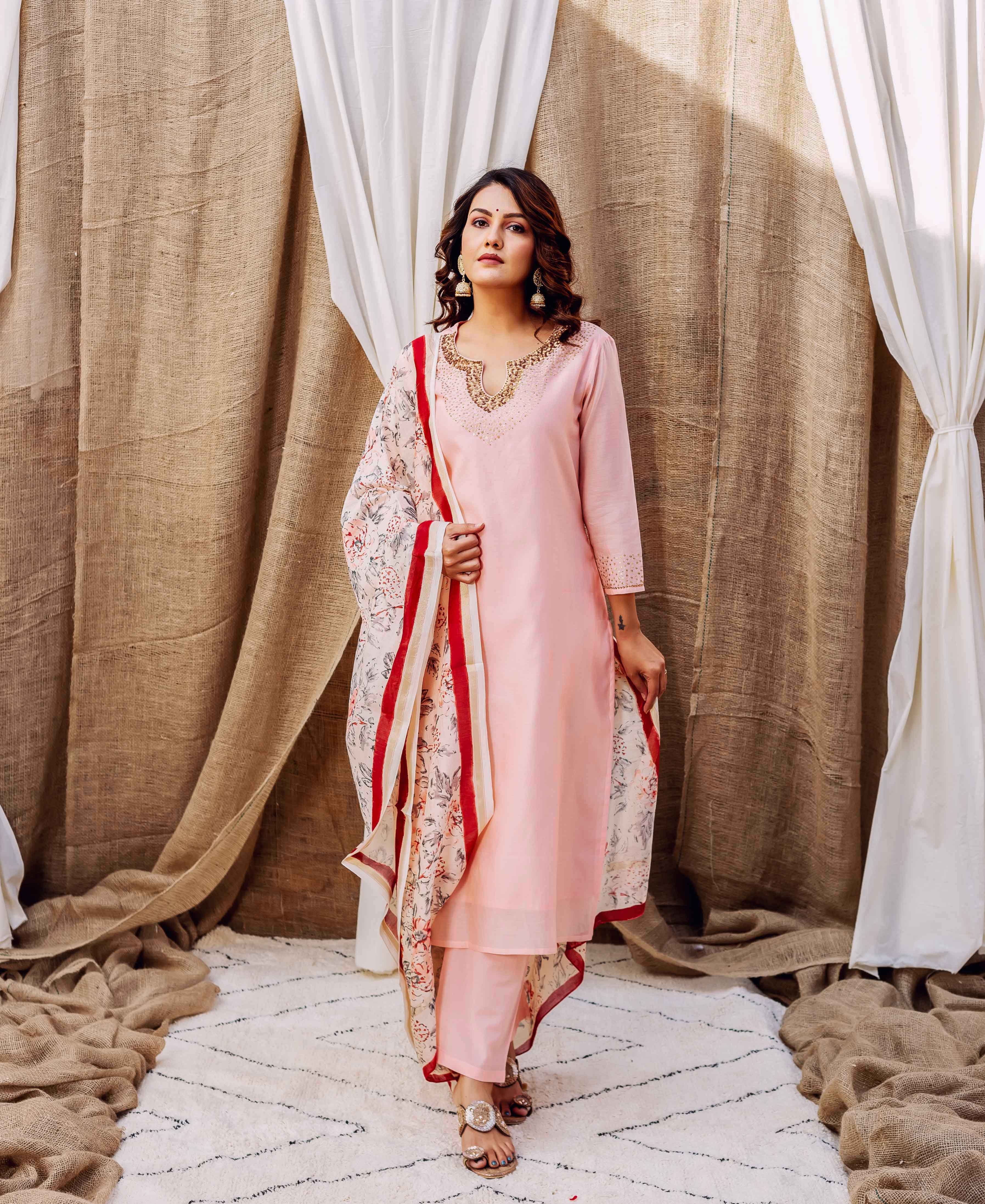 On a model, a rose pink kurta set featuring an embroidered neck and floral printed dupatta.