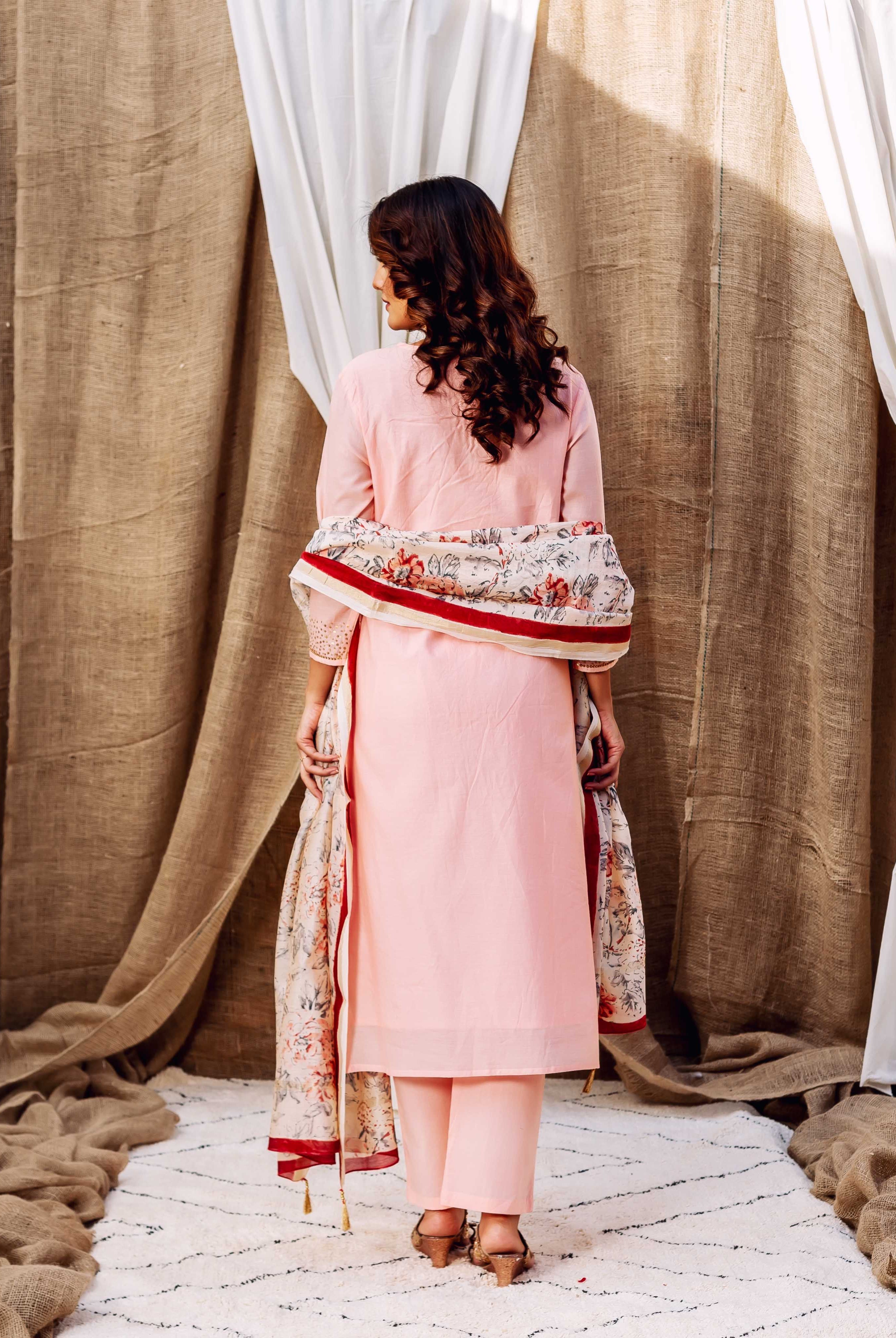 Back view of a model wearing a rose pink kurta set with a patterned floral dupatta.