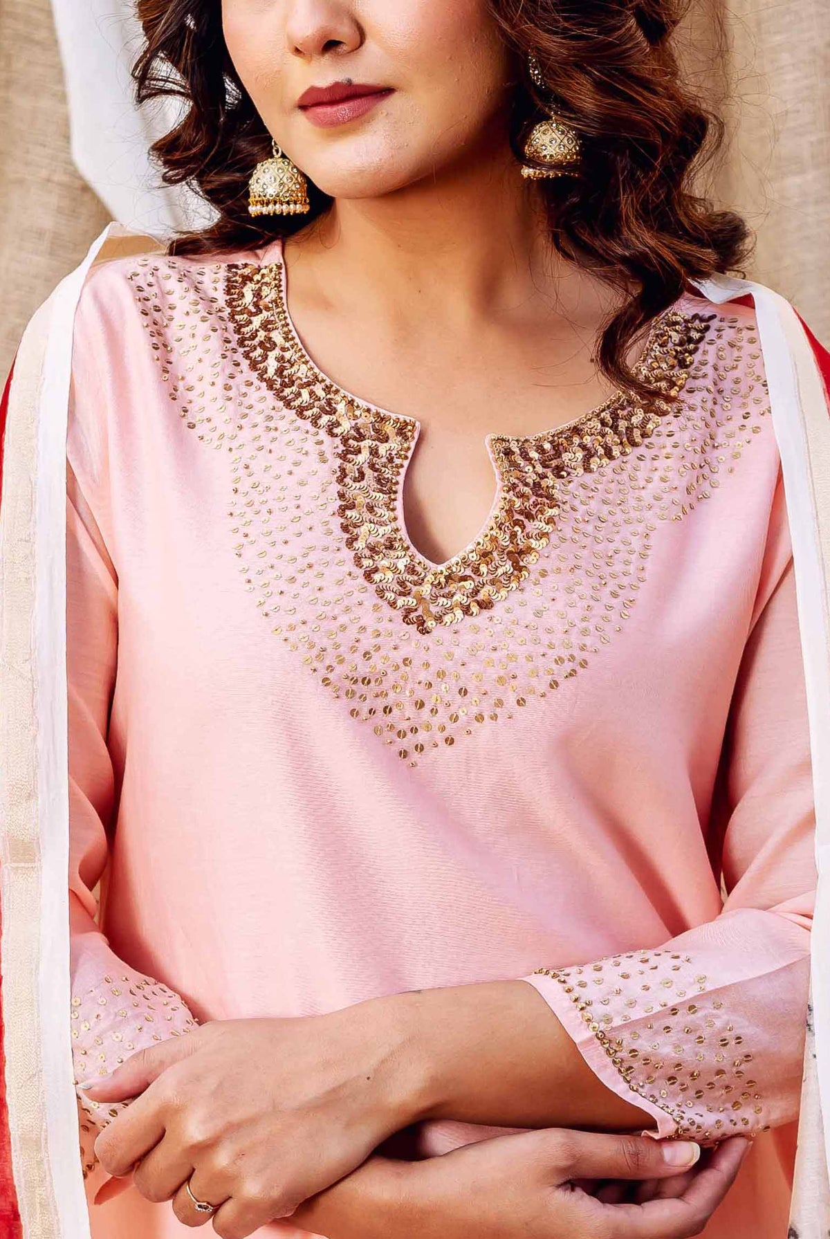 Model wears rose pink kurta with golden embellished neckline and a printed dupatta.