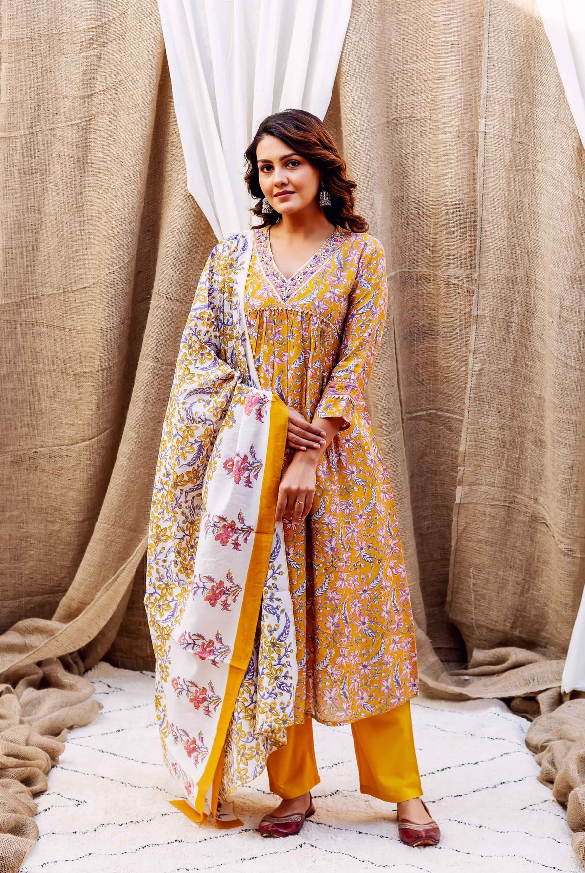 A model wearing a yellow floral block-printed kurta with matching pants and dupatta.
