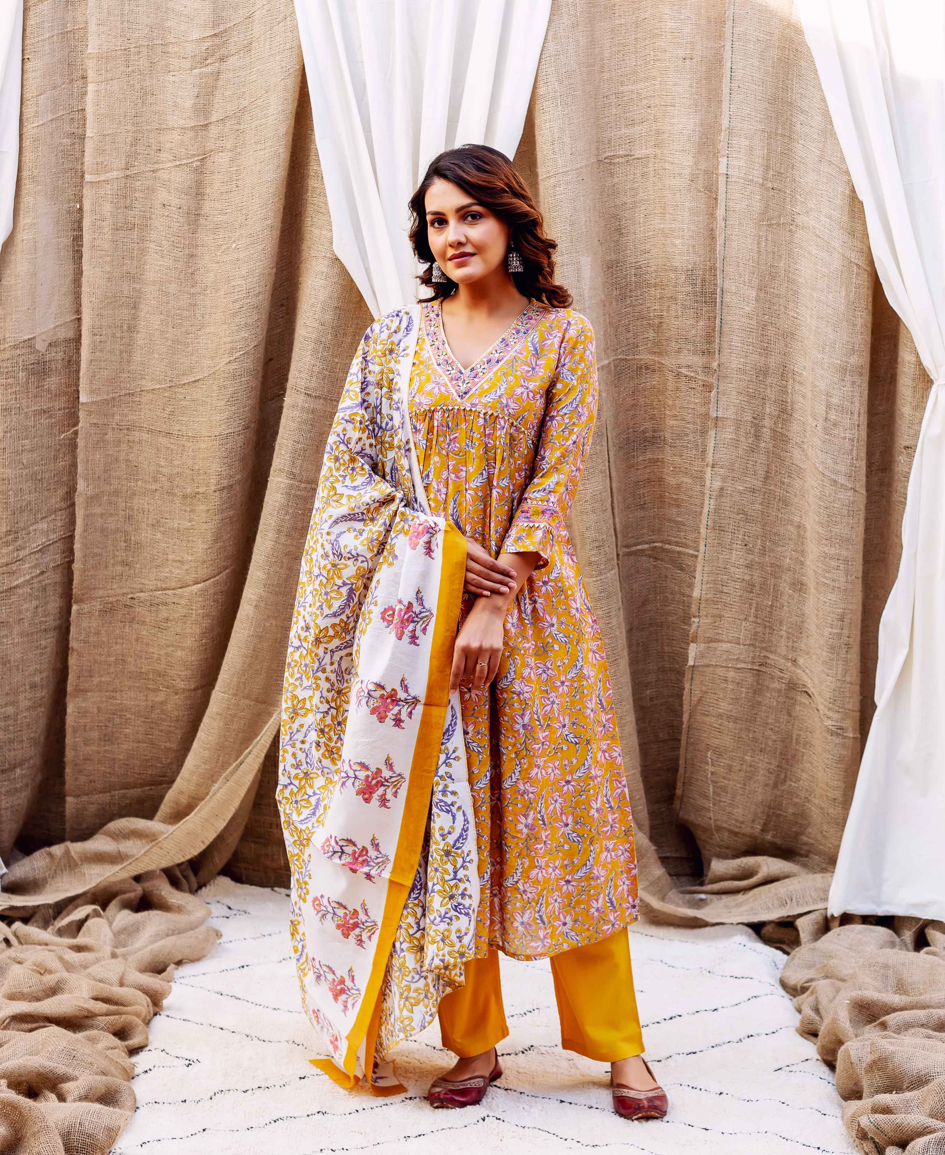 A model wearing a yellow floral block-printed kurta with matching pants and dupatta.