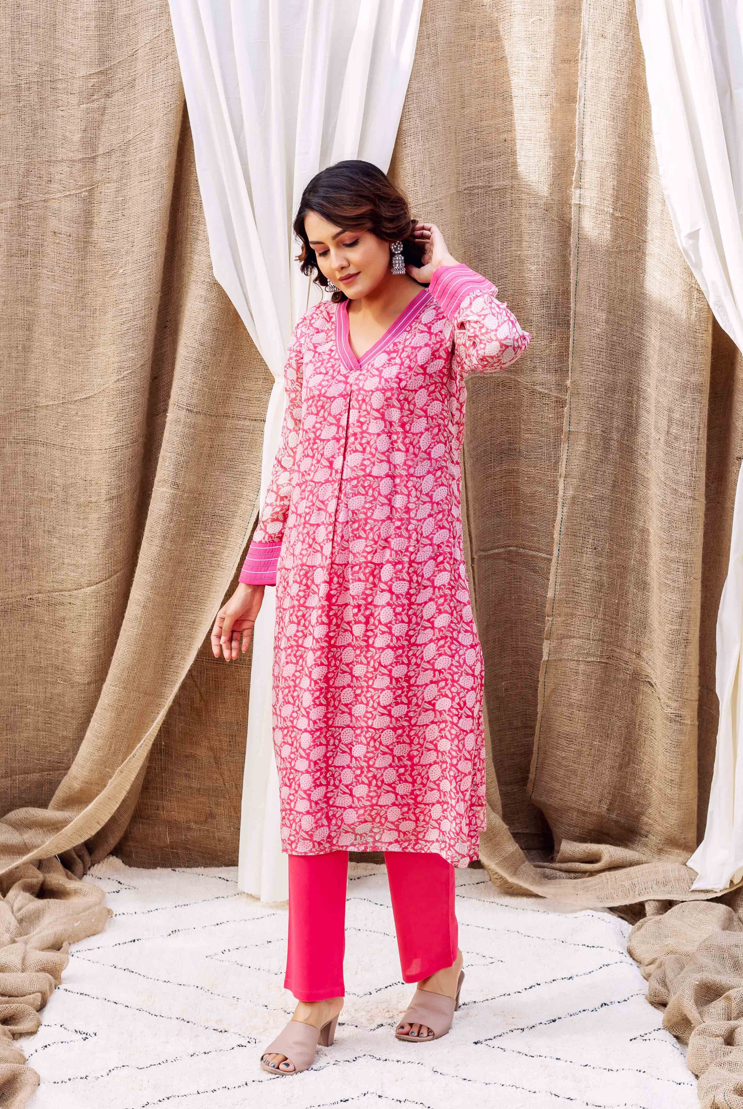Model in a vibrant pink hand-printed organza kurta with white ethnic motifs.