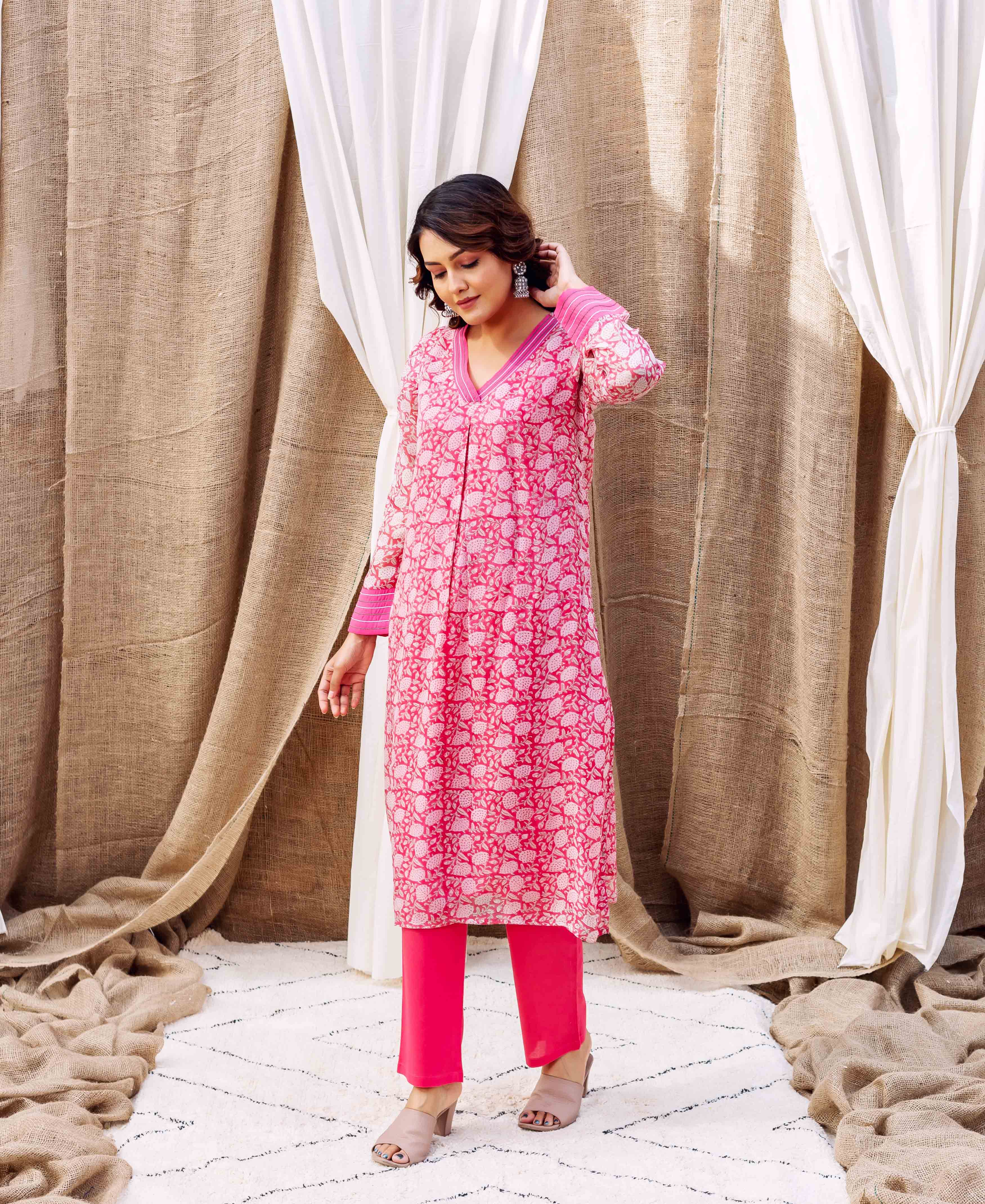 Model in a vibrant pink hand-printed organza kurta with white ethnic motifs.