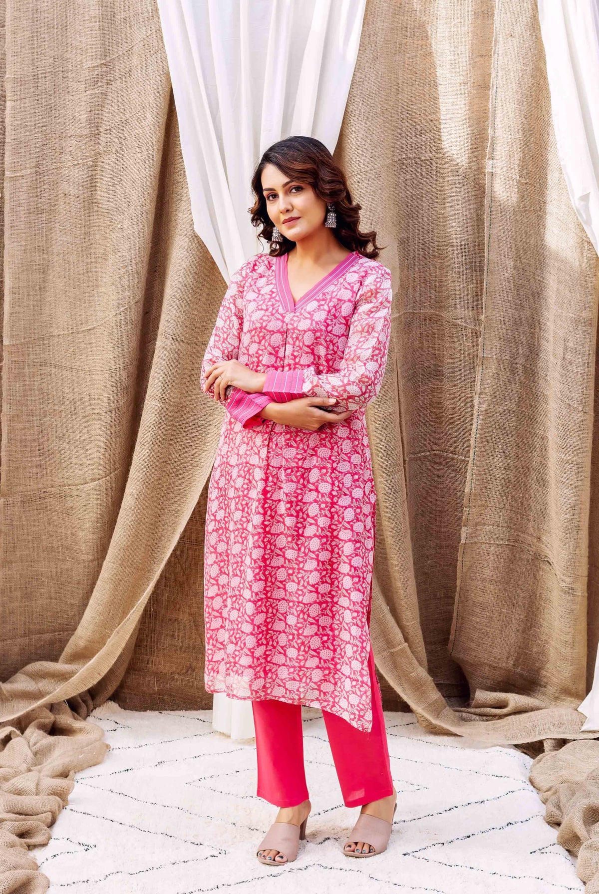 Full-body shot of model wearing pink floral hand-printed kurta and matching pants.